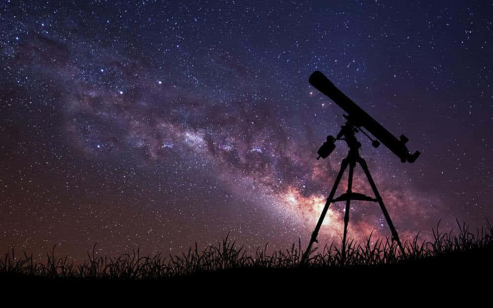 Stars 桌布 壁紙 — 草地上望遠鏡的剪影，指向在繁星點點的夜空中閃耀的銀河系。