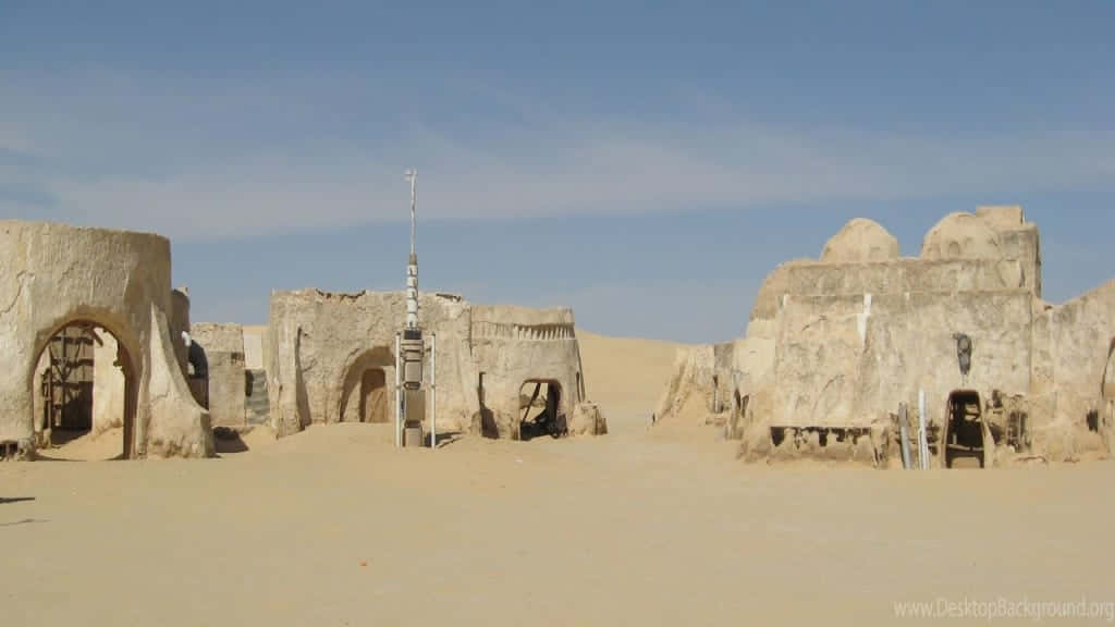 Mos Eisley 桌布 壁紙 — 荒涼的沙漠廢墟，沙質結構在清澈的藍天下。