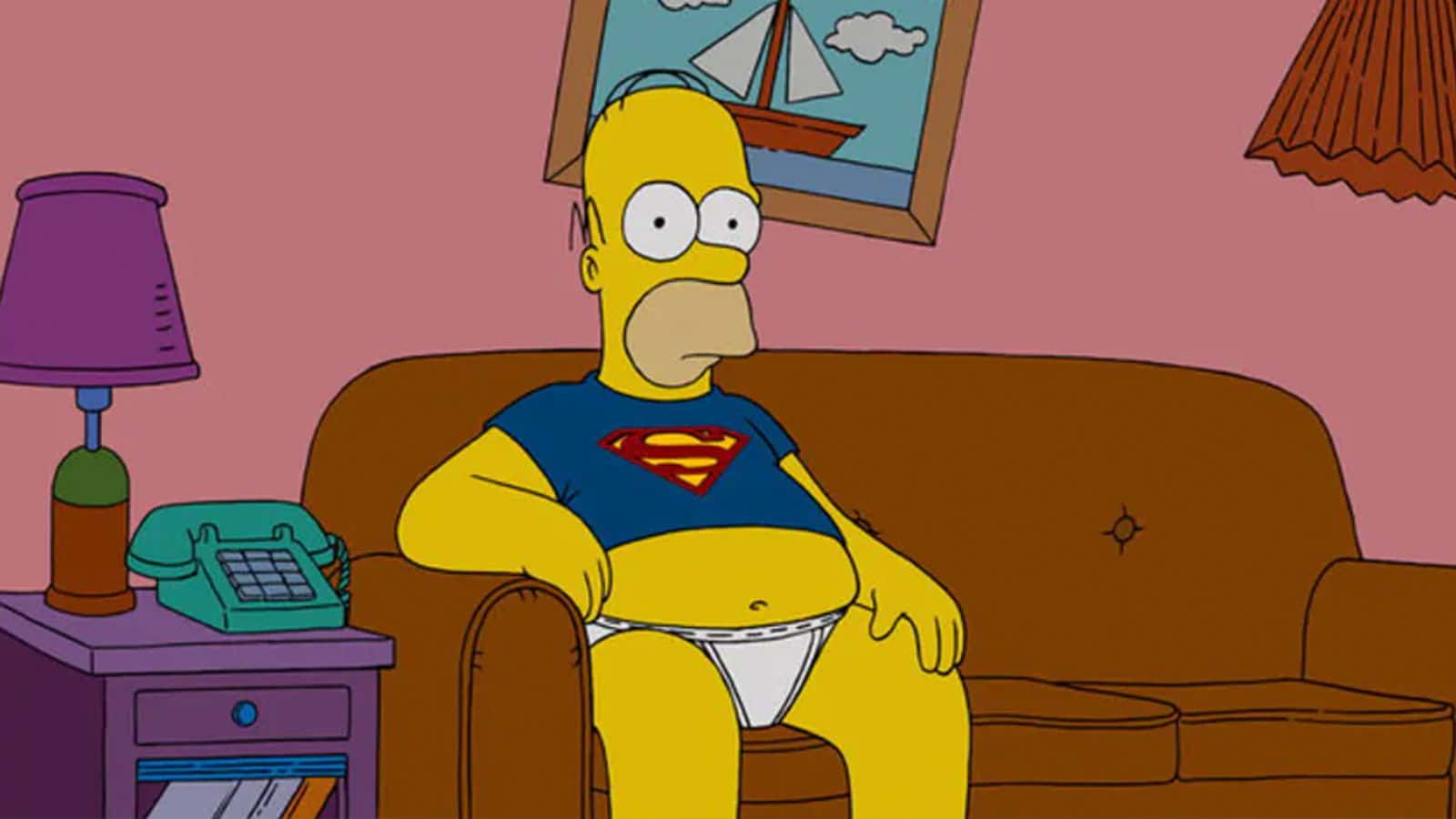 Homer Simpson 桌布 壁紙 — 荷馬·辛普森坐在一張棕色沙發上，穿著超人T恤和白色內褲，身處粉紅色牆壁的客廳。
