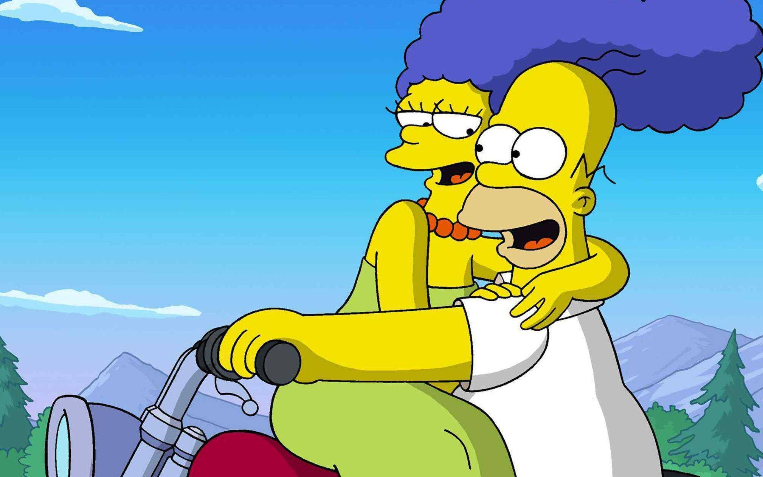 marge 桌布 壁紙 — 荷馬和瑪吉·辛普森在晴朗的藍天下騎摩托車穿過山區景觀。