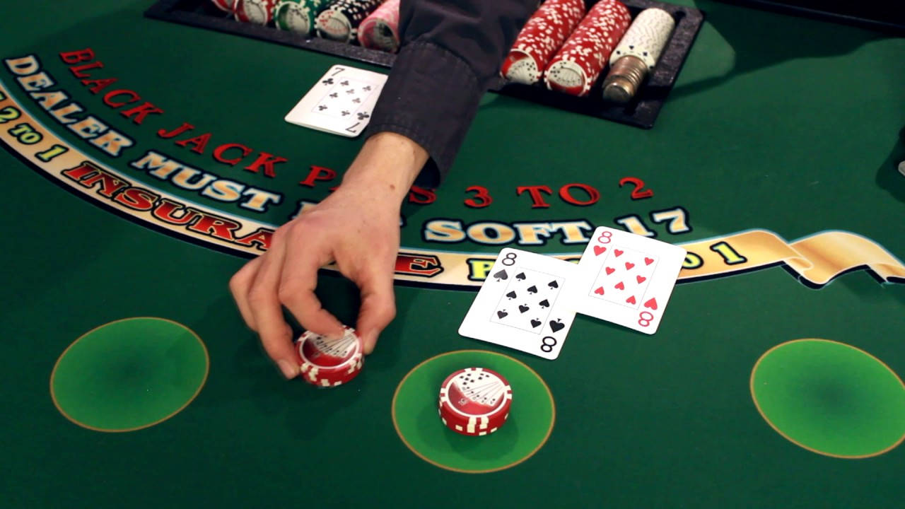 Casino 桌布 壁紙 — 莊家的手將一個紅白色的籌碼放在綠色的二十一點桌上，桌上可見紙牌和籌碼堆。