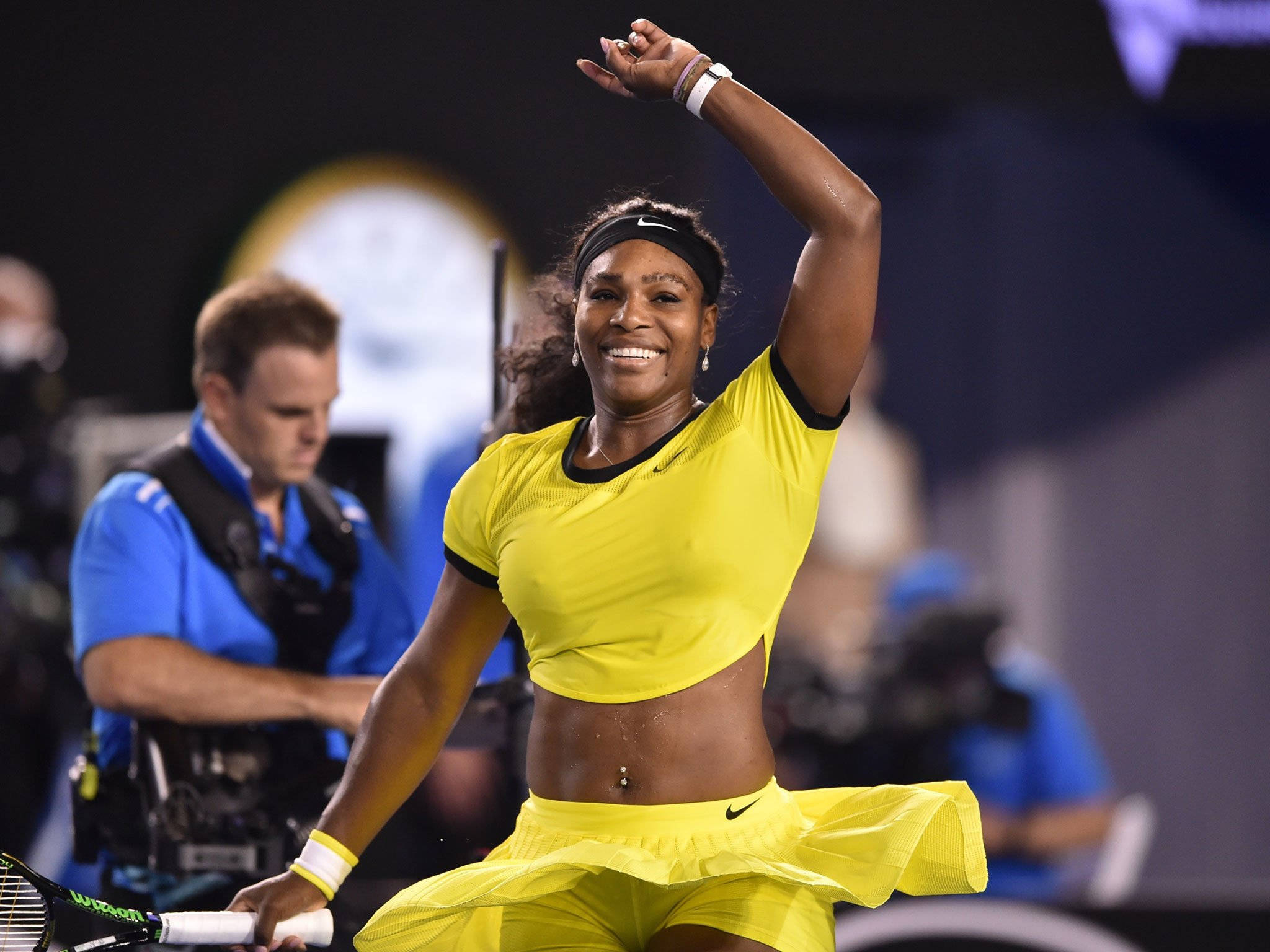 Serena 桌布 壁紙 — 莎蓮娜威廉斯在球場燈光下，身穿亮黃色網球服裝慶祝勝利。