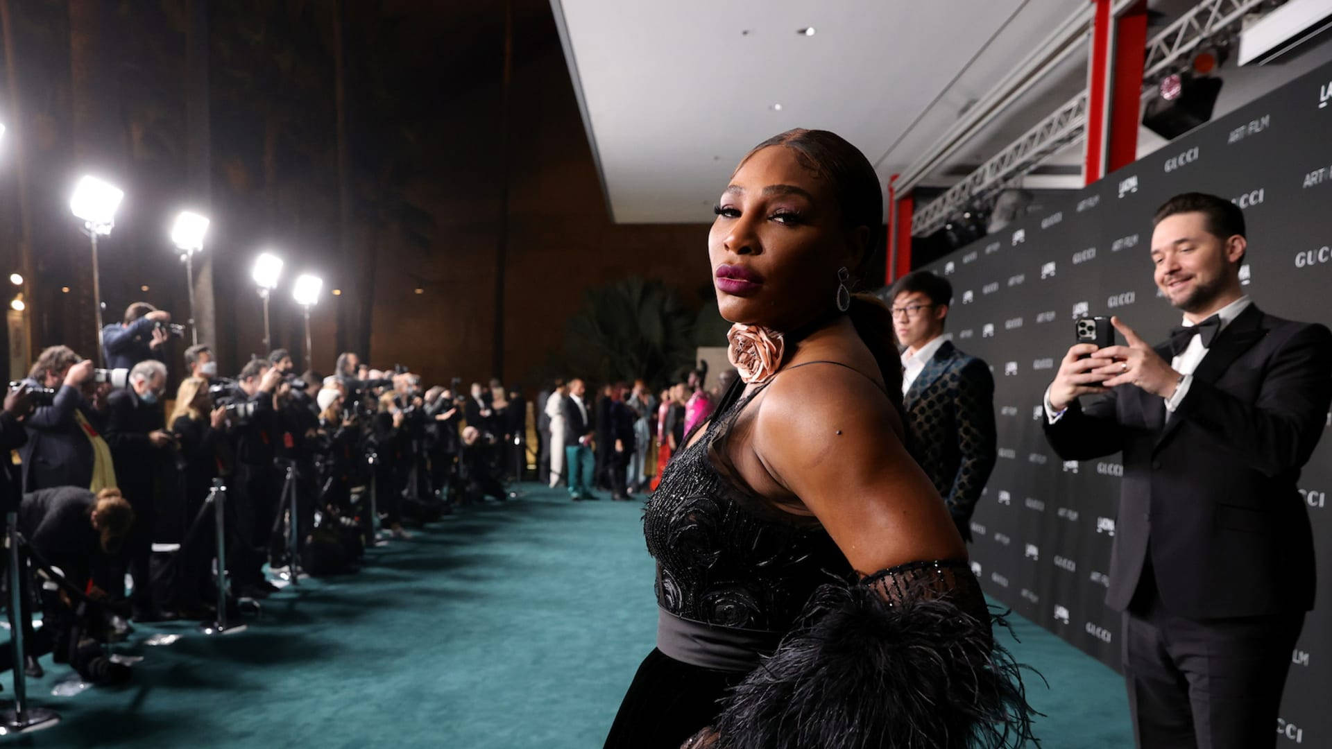 Serena 桌布 壁紙 — 莎蓮娜威廉絲在一個華麗的晚間活動中，自信地在青綠色地毯上擺姿勢，周圍有攝影師和粉絲。