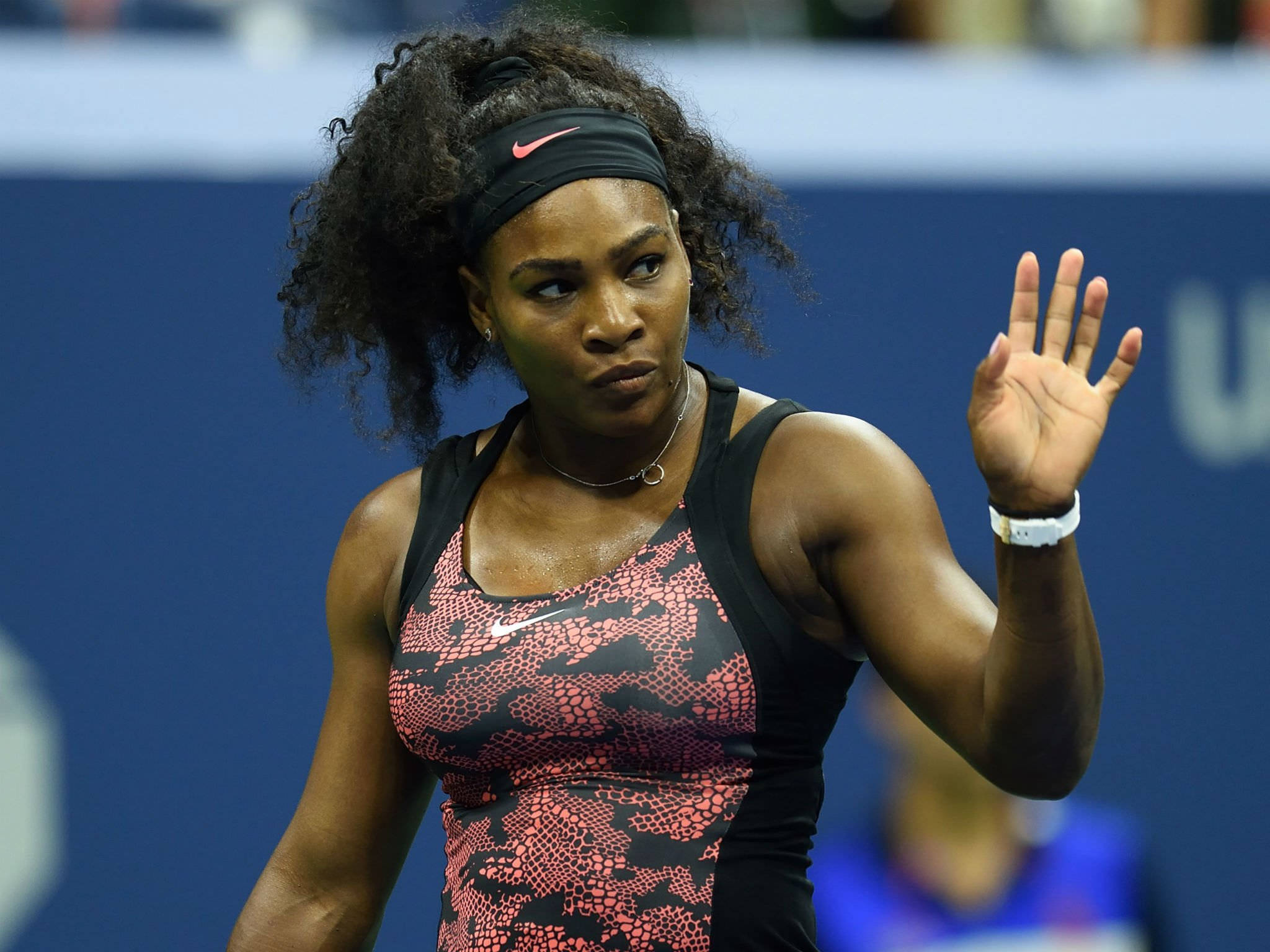 Serena 桌布 壁紙 — 莎蓮娜威廉絲在激烈的網球比賽中向人群揮手，身穿粉紅色和黑色圖案的運動上衣。
