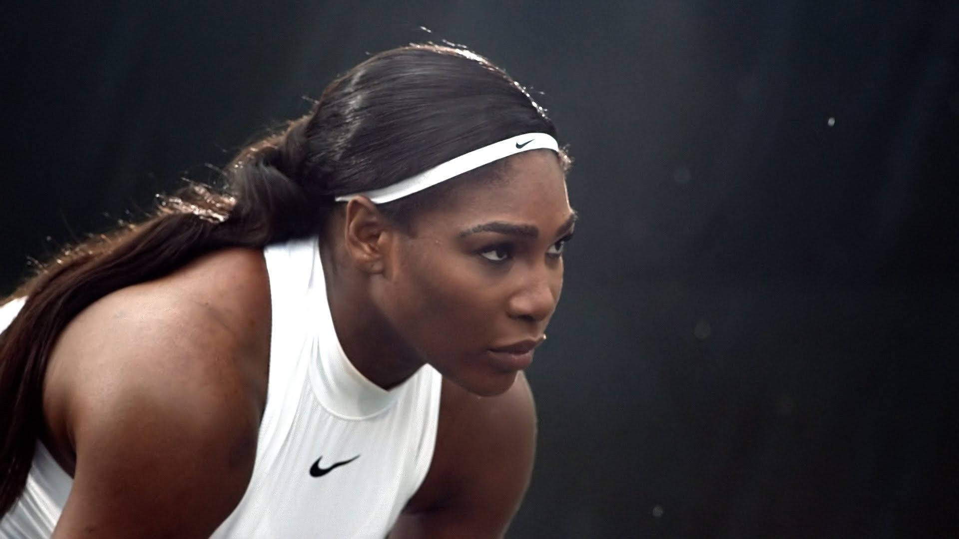 Serena 桌布 壁紙 — 莎蓮娜威廉絲在網球比賽中全神貫注，身穿白色Nike裝備，背景為深色。