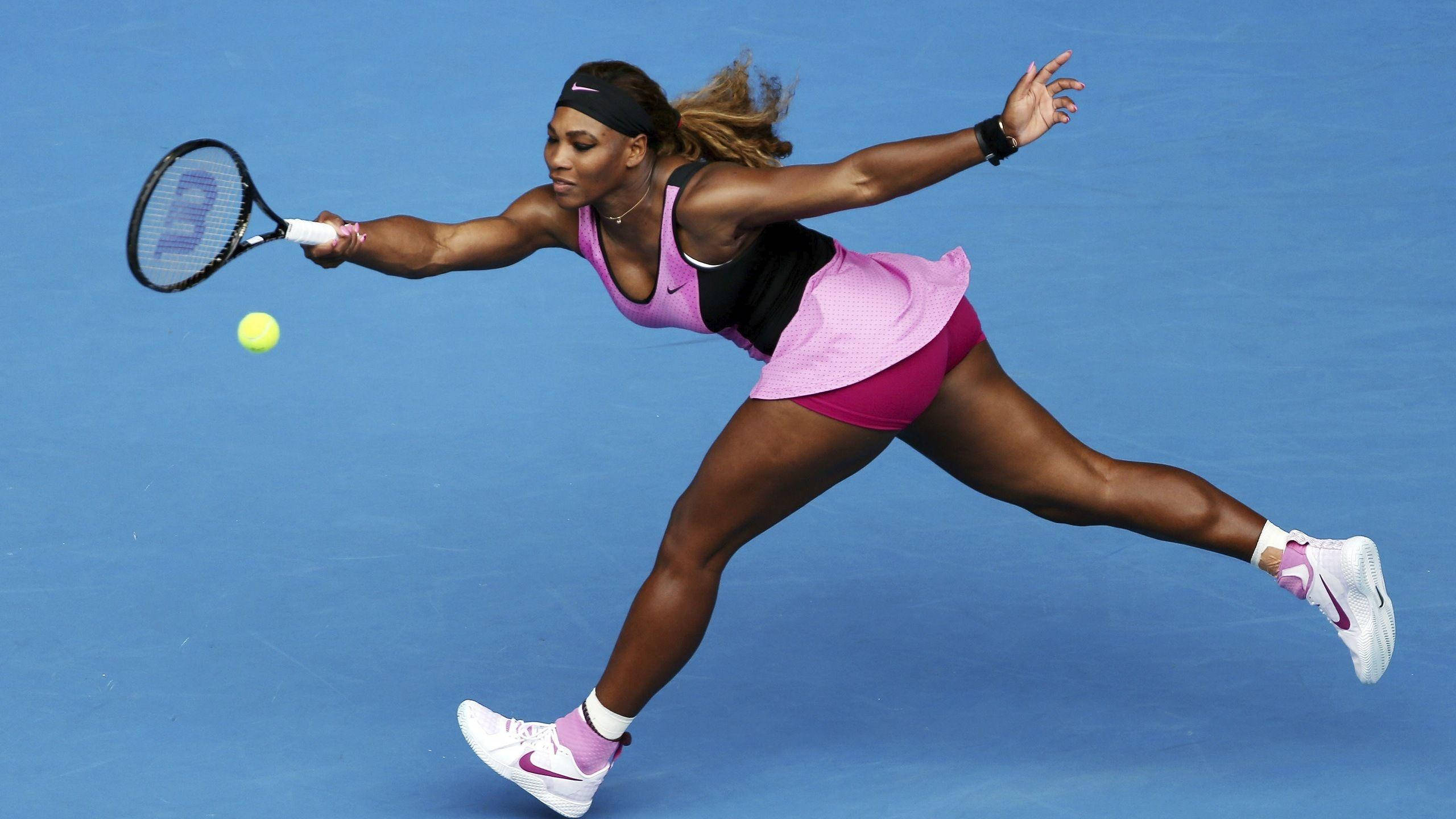 Serena 桌布 壁紙 — 莎蓮娜威廉絲在藍色硬地球場上動態地跨步，以高度專注和運動優雅擊打網球。