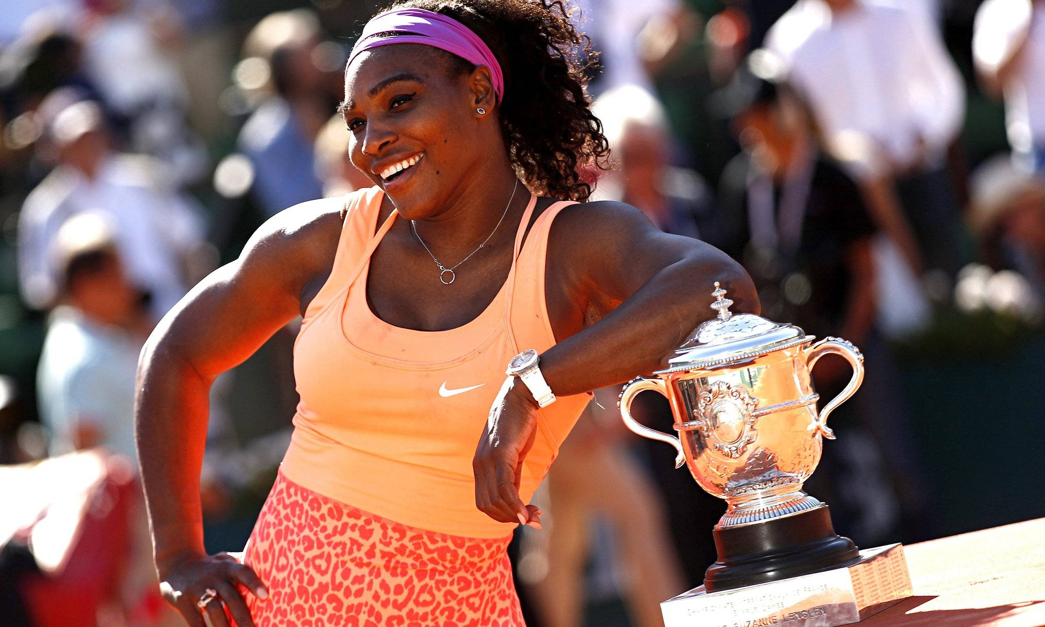 Serena 桌布 壁紙 — 莎蓮娜威廉絲在陽光明媚的紅土網球場上，手持閃閃發光的冠軍獎盃，滿懷喜悅。