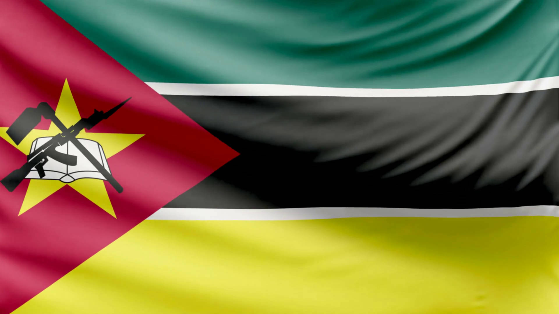 Mozambique 桌布 壁紙 — 莫三比克國旗動態飄揚，帶有紅、綠、黃、黑條紋，中央有星、書本、步槍和鋤頭的標誌。