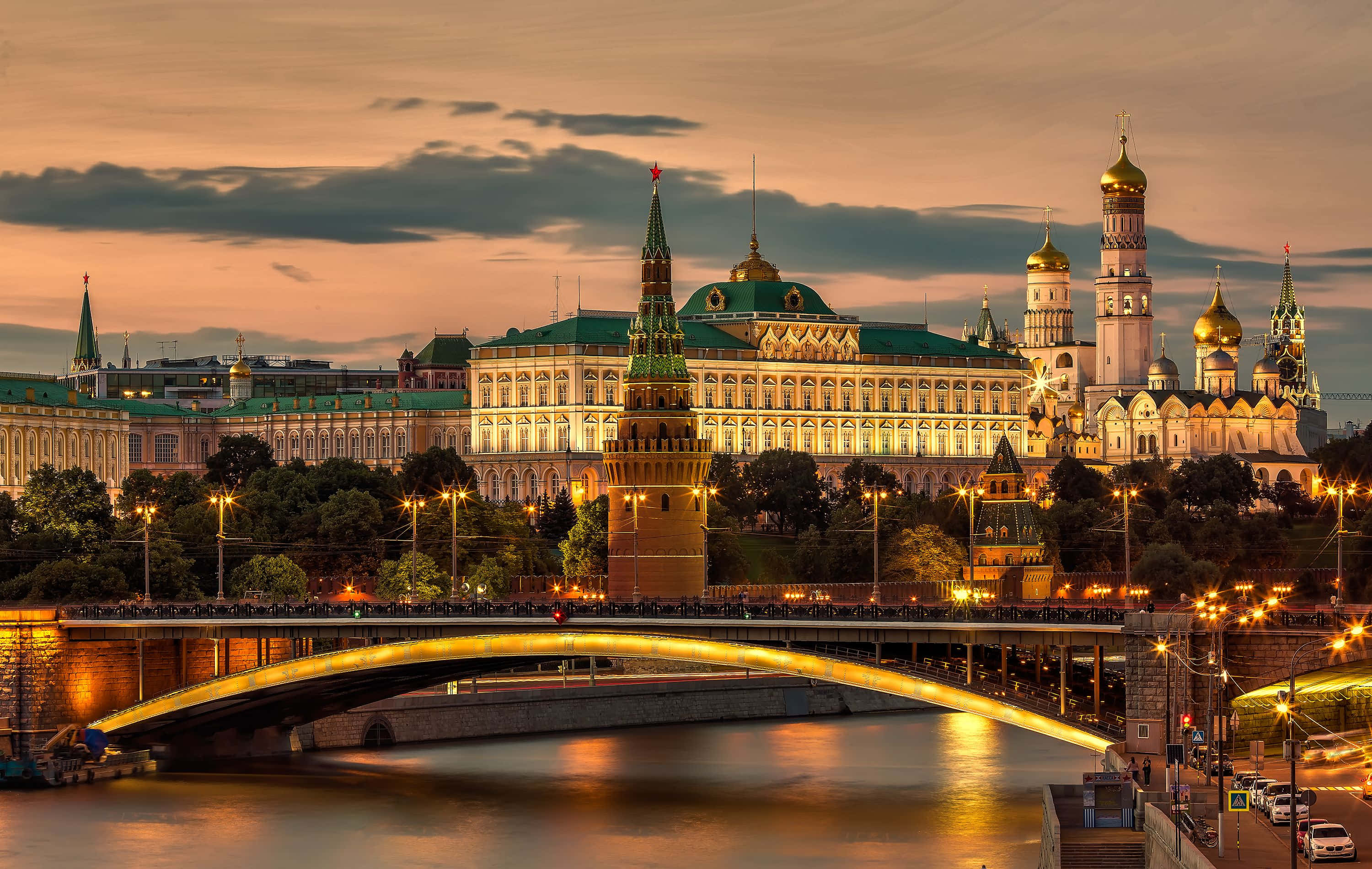 Russian 桌布 壁紙 — 莫斯科克里姆林宮的金色圓頂和燈火通明的塔樓在黃昏時分在流動的河流和拱橋上方閃耀。