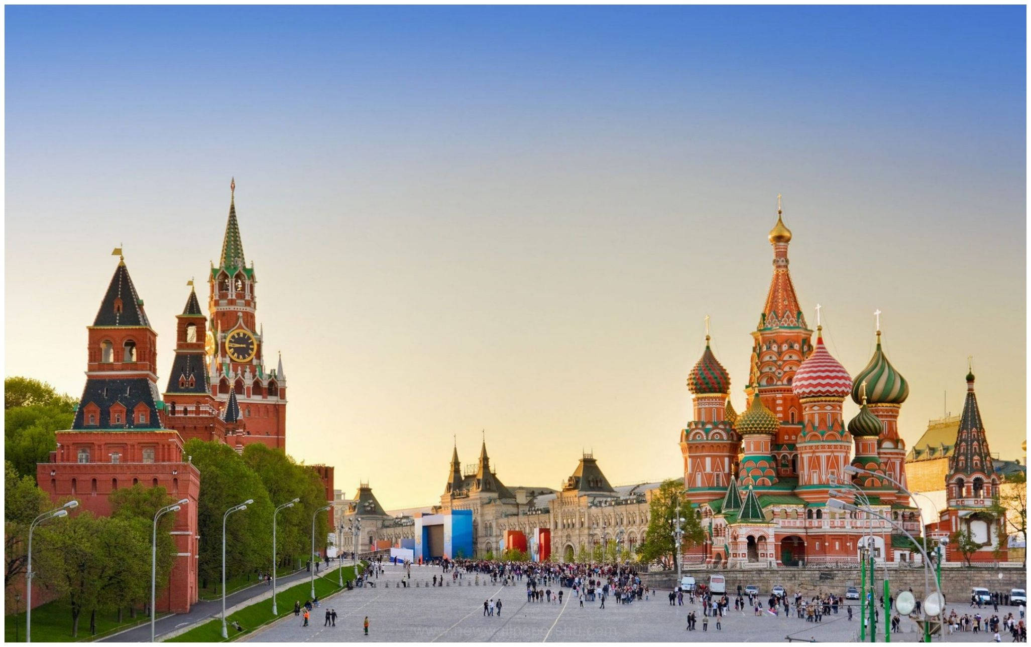 Russia 桌布 壁紙 — 莫斯科紅磚克里姆林宮塔樓和色彩繽紛的洋蔥形圓頂聖瓦西里大教堂在金色夕陽下閃耀。