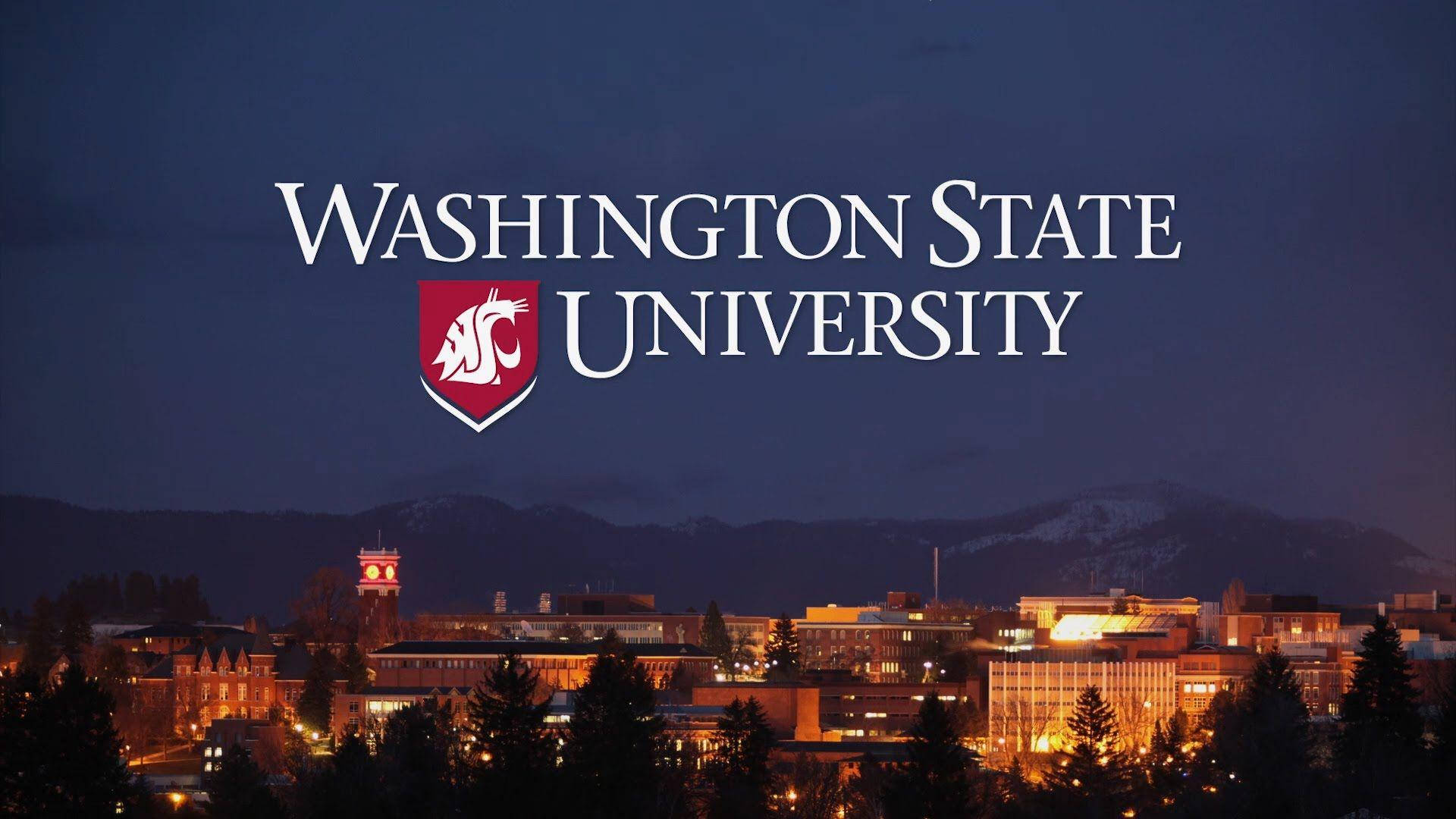 Washington 桌布 壁紙 — 華盛頓州立大學校園在黃昏時分，積雪的山脈在發光的建築物後面。