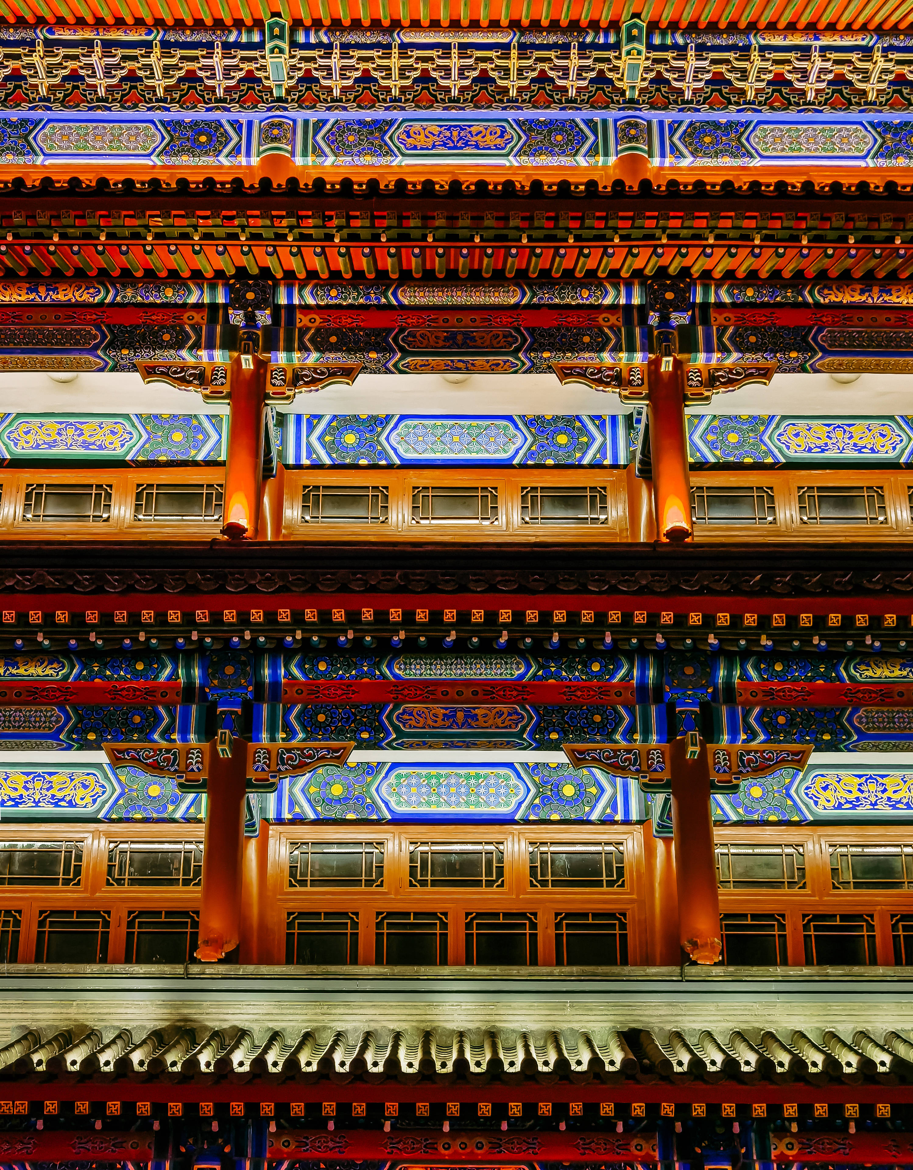 Honor 桌布 壁紙 — 華麗的傳統中式建築夜景，階梯式屋簷和木樑上閃耀著藍色、金色和紅色的裝飾圖案。