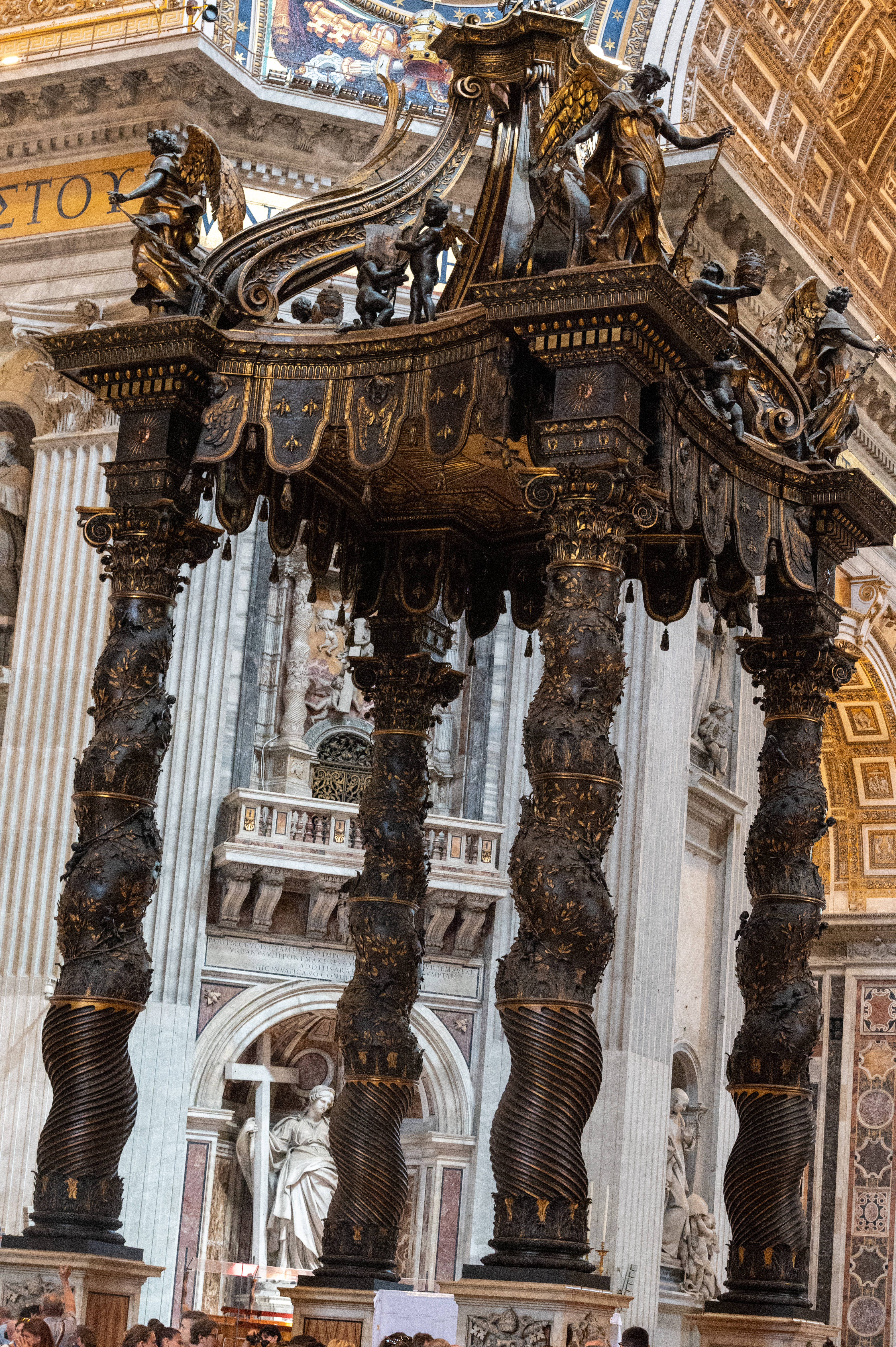 Vatican 桌布 壁紙 — 華麗的青銅華蓋，帶有扭曲柱子和天使雕像，雄偉地矗立在鍍金的大教堂內部。