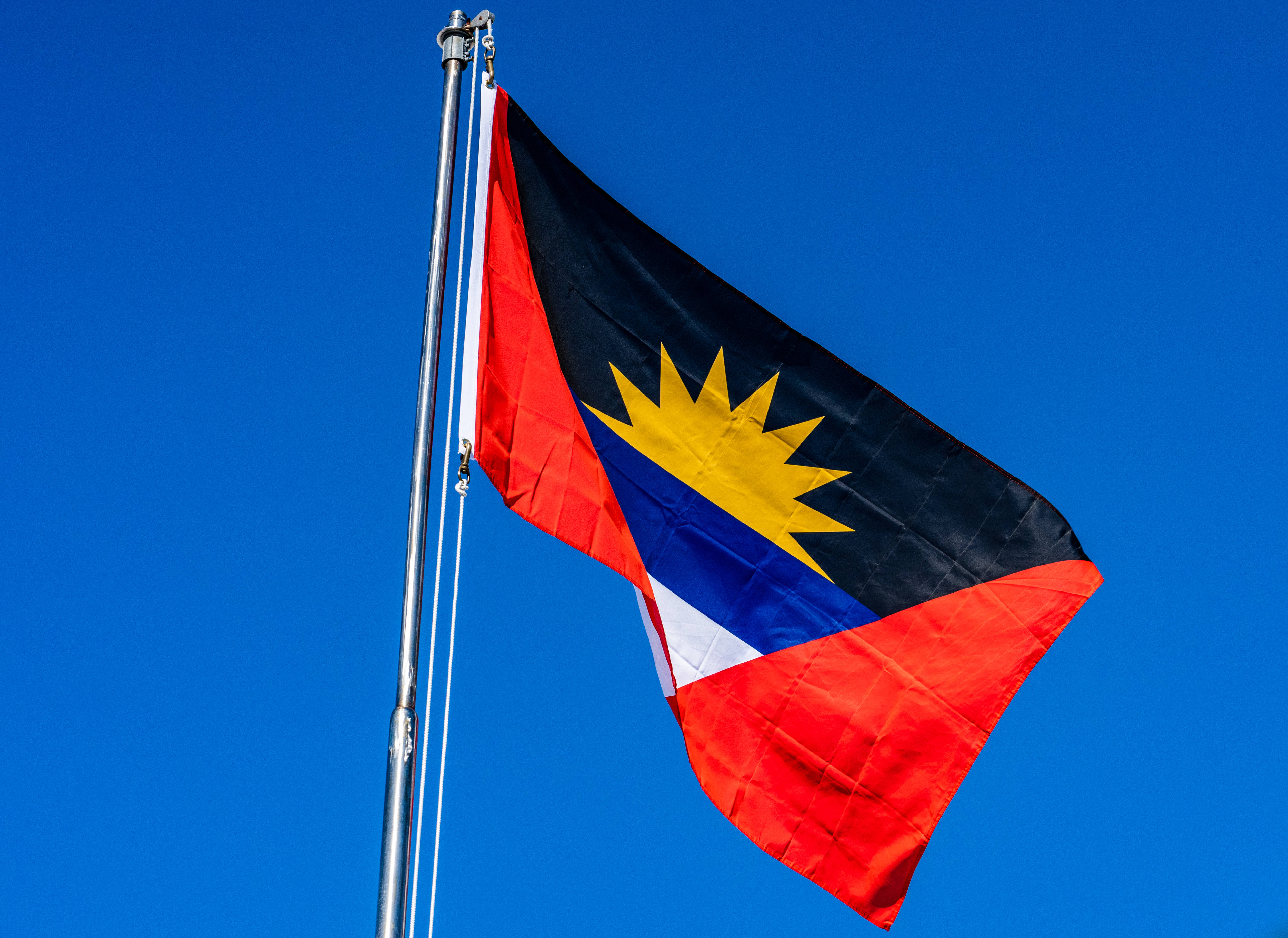 Antigua And Barbuda 桌布 壁紙 — 菲律賓國旗在晴朗的藍天下驕傲地飄揚。