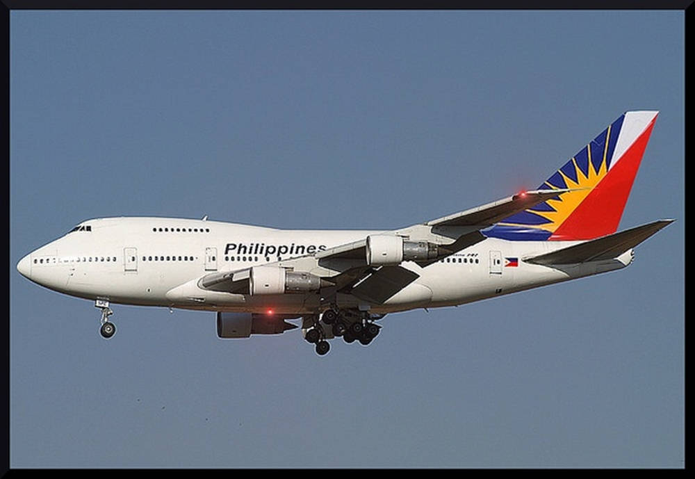 壁紙 — 菲律賓航空波音747在晴朗藍天中飛行，起落架已放下。