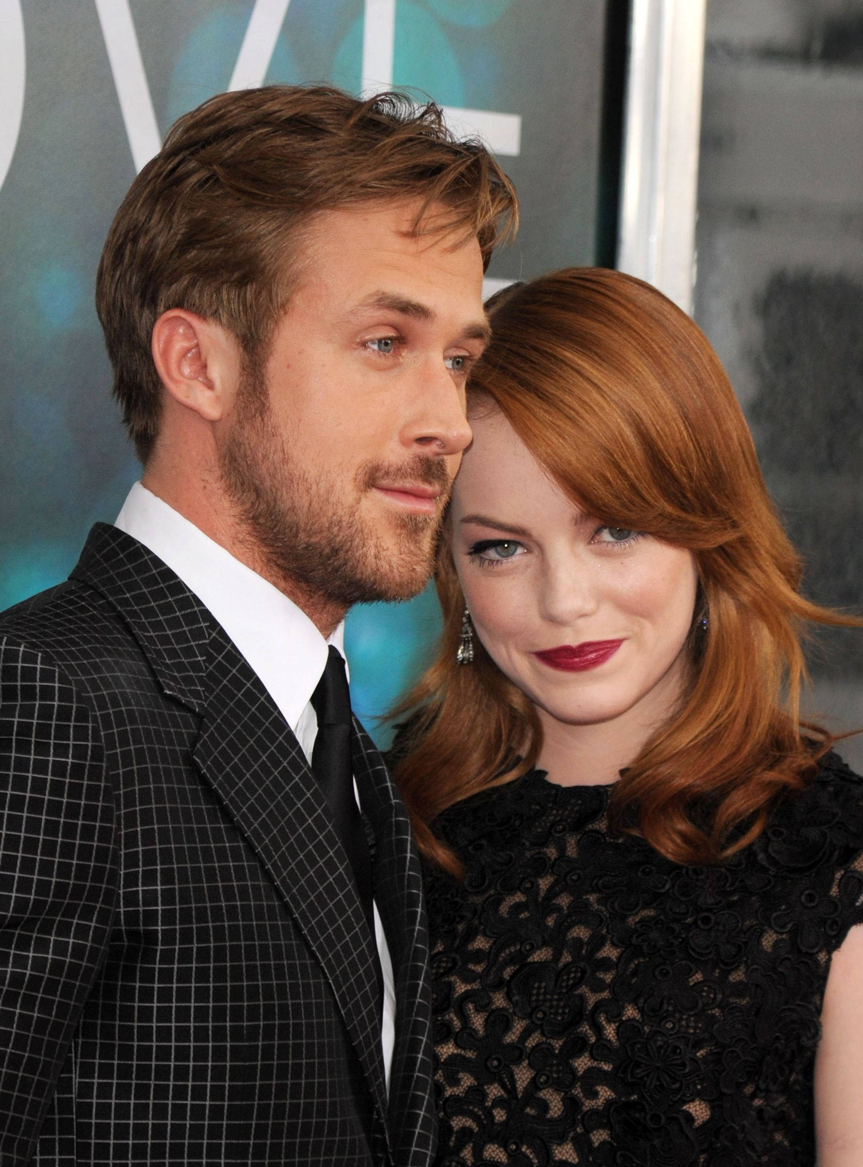 Ryan Gosling 桌布 壁紙 — 萊恩葛斯林和艾瑪史東在紅地毯活動上緊密擺姿勢，穿著正式黑色服裝，塗上紅色唇膏和造型頭髮。