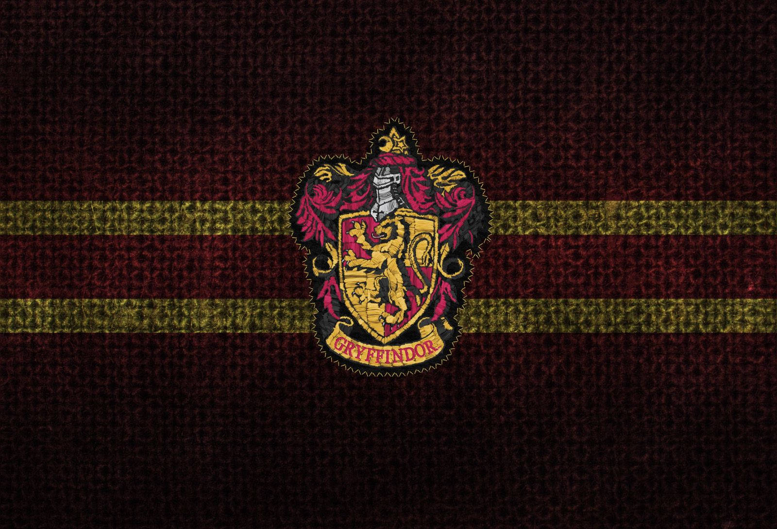 Gryffindor 桌布 壁紙 — 葛萊芬多學院徽章刺繡在帶有金色條紋的質感栗紅色布料上。