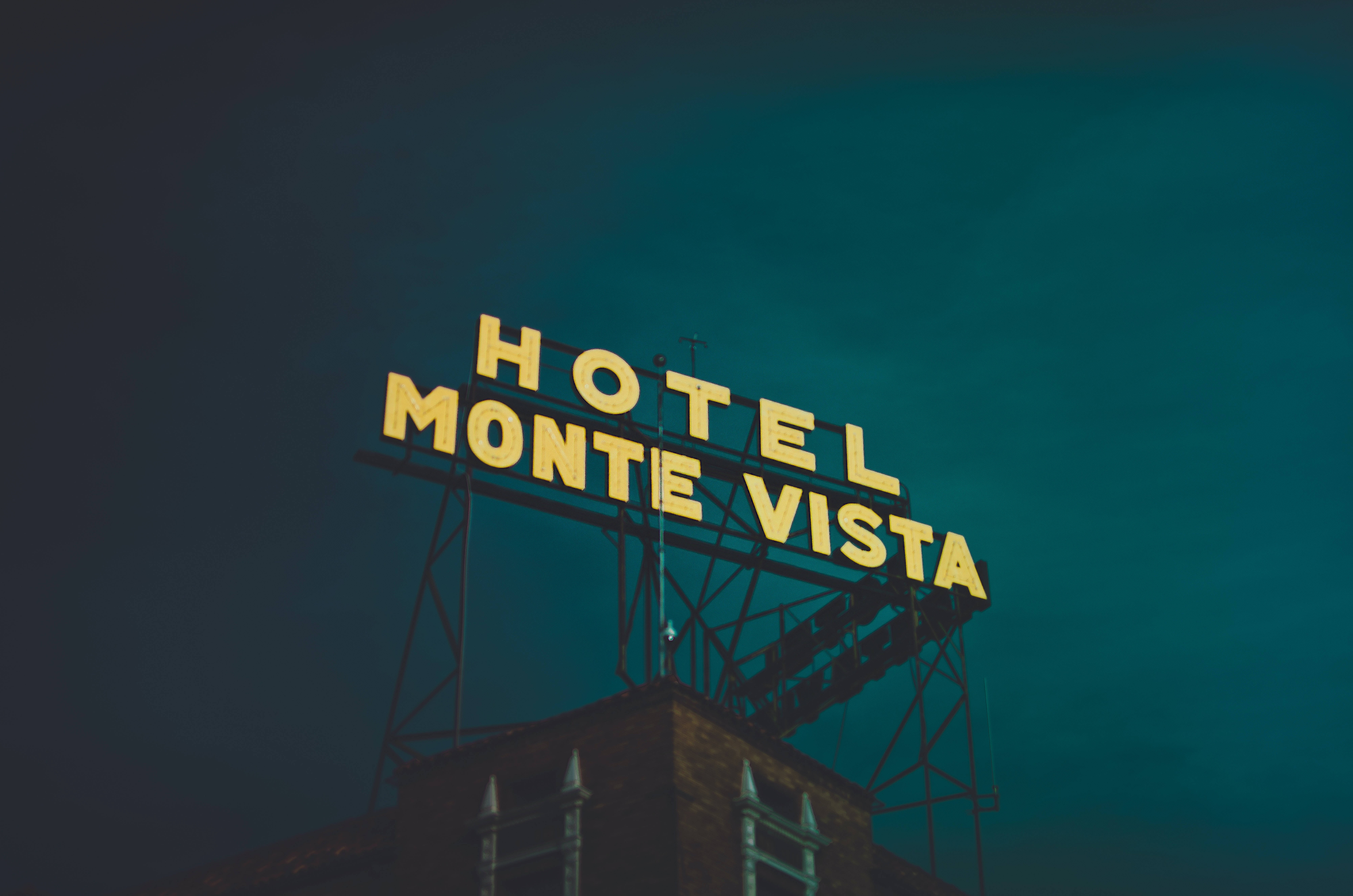 Hotel 桌布 壁紙 — 蒙特維斯塔酒店的復古黃色霓虹燈牌在憂鬱的藍綠色夜空中閃耀。