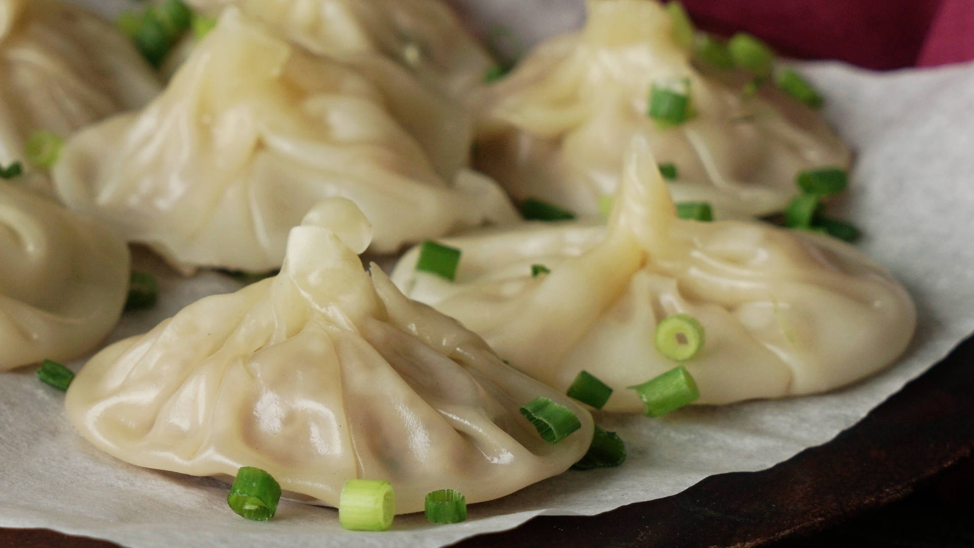 steam 桌布 壁紙 — 蒸餃子配上蔥花，放在深色木托盤的烘焙紙上，熱氣騰騰。