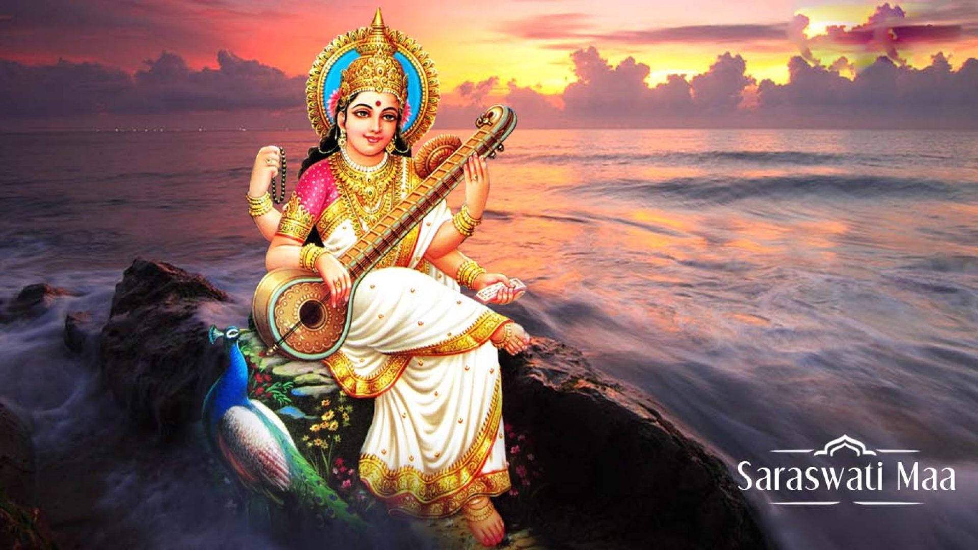 Saraswati Mata 桌布 壁紙 — 薩拉斯瓦蒂女神優雅地坐在海邊岩石上彈奏維納琴，下方波濤洶湧，天空燃燒著夕陽。