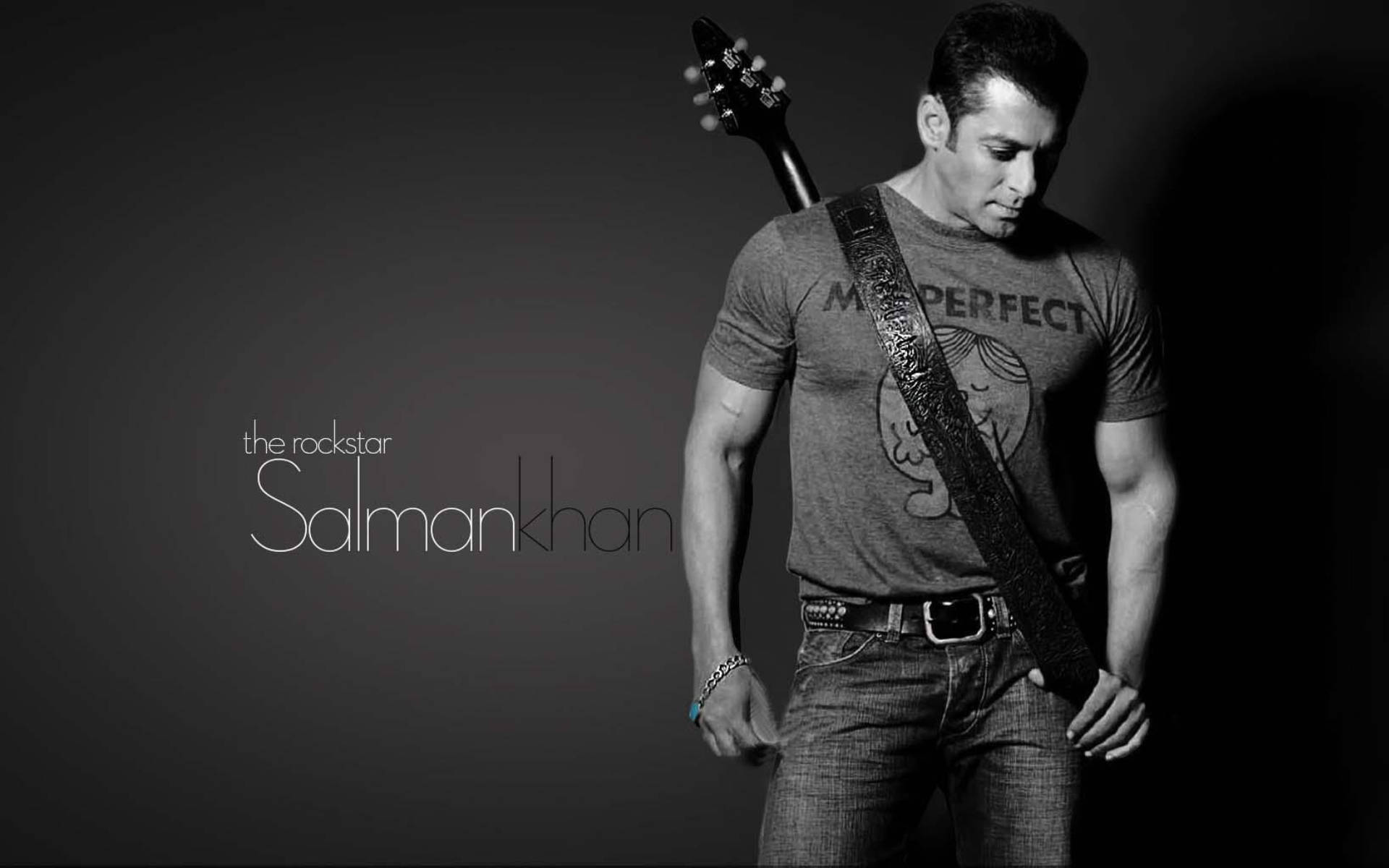 Salman Khan 桌布 壁紙 — 薩爾曼·汗自信地擺姿勢，肩上扛著吉他，拍攝一張氣氛濃厚的黑白工作室肖像。