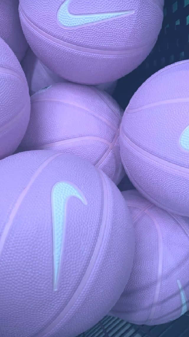 Nike 節奏籃球 桌布 壁紙 — 薰衣草色籃球帶有發光白色Nike標誌，堆疊在籃子中的特寫。