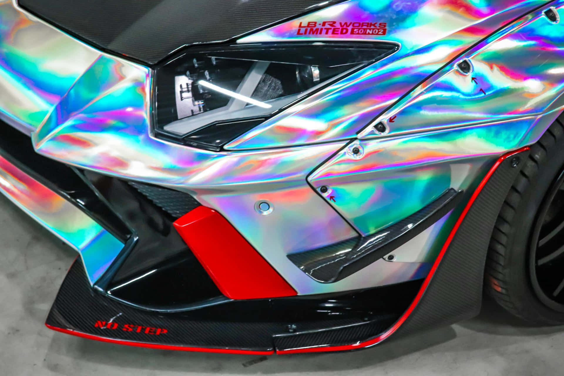 Lamborghini Aventador 桌布 壁紙 — 藍寶堅尼近距離特寫，彩虹色車漆在棱角分明的前保險桿和碳纖維飾件上反射光線。