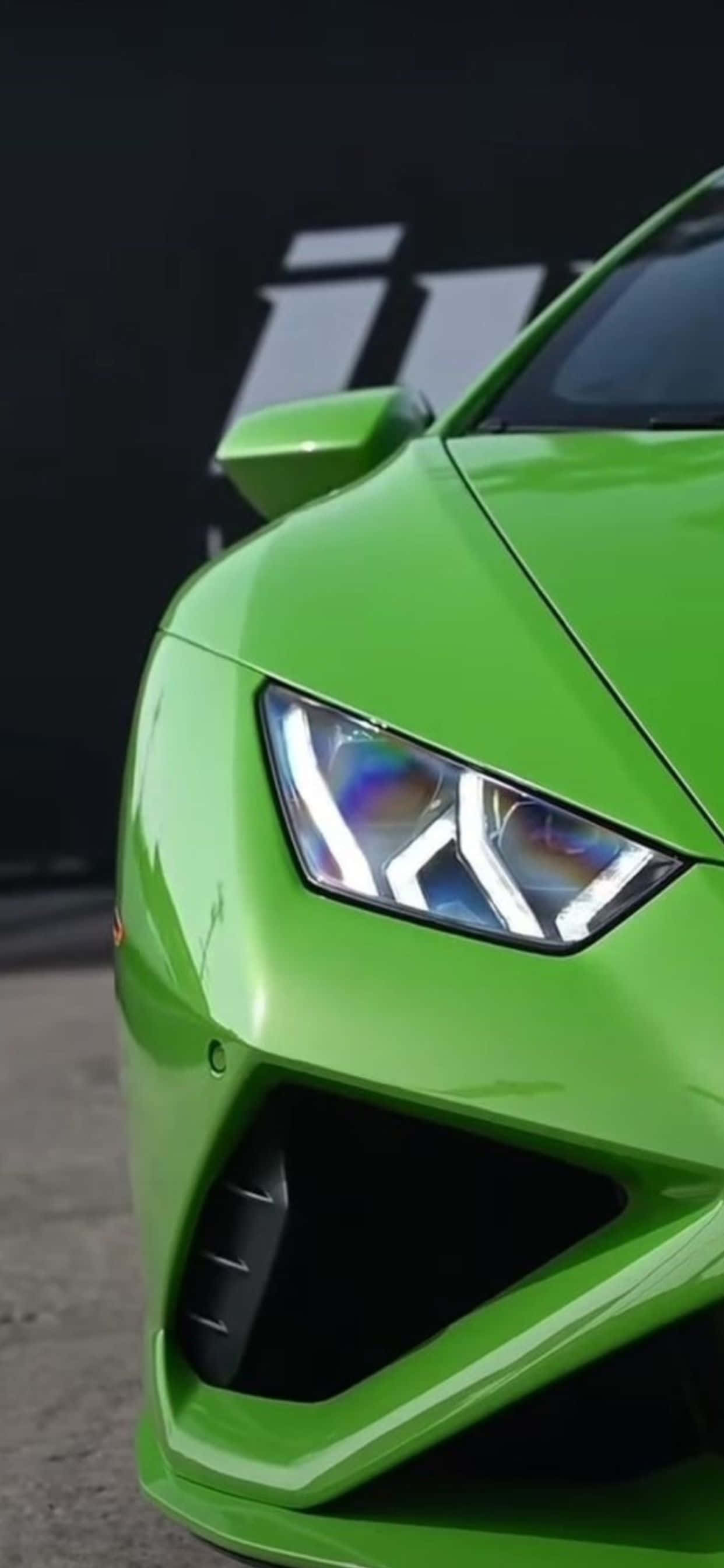 Lamborghini Phone 桌布 壁紙 — 藍寶堅尼鮮綠色跑車的侵略性車頭與發光LED頭燈的特寫。