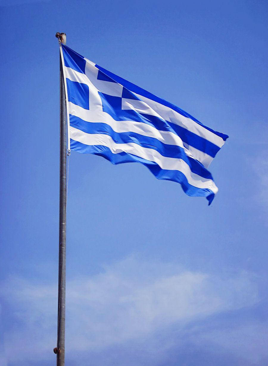 greek 桌布 壁紙 — 藍白條紋和十字架的希臘國旗在晴朗的藍天下自豪地飄揚。