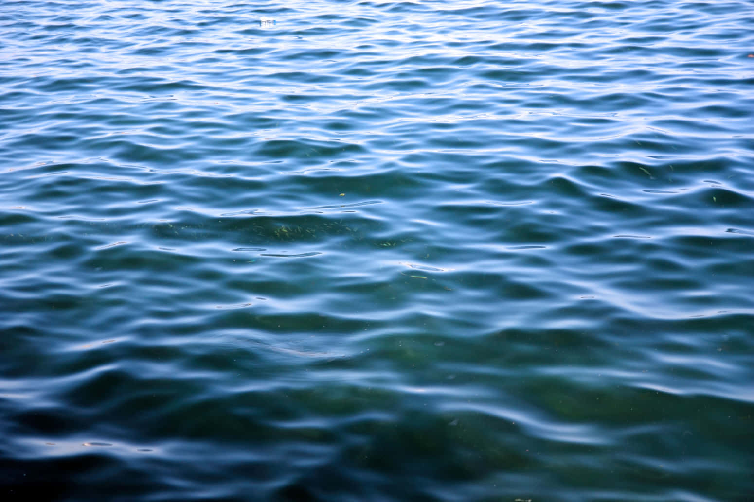 Ocean Water 桌布 壁紙 — 藍綠色水波輕柔蕩漾的特寫，柔和光線在水面反射。