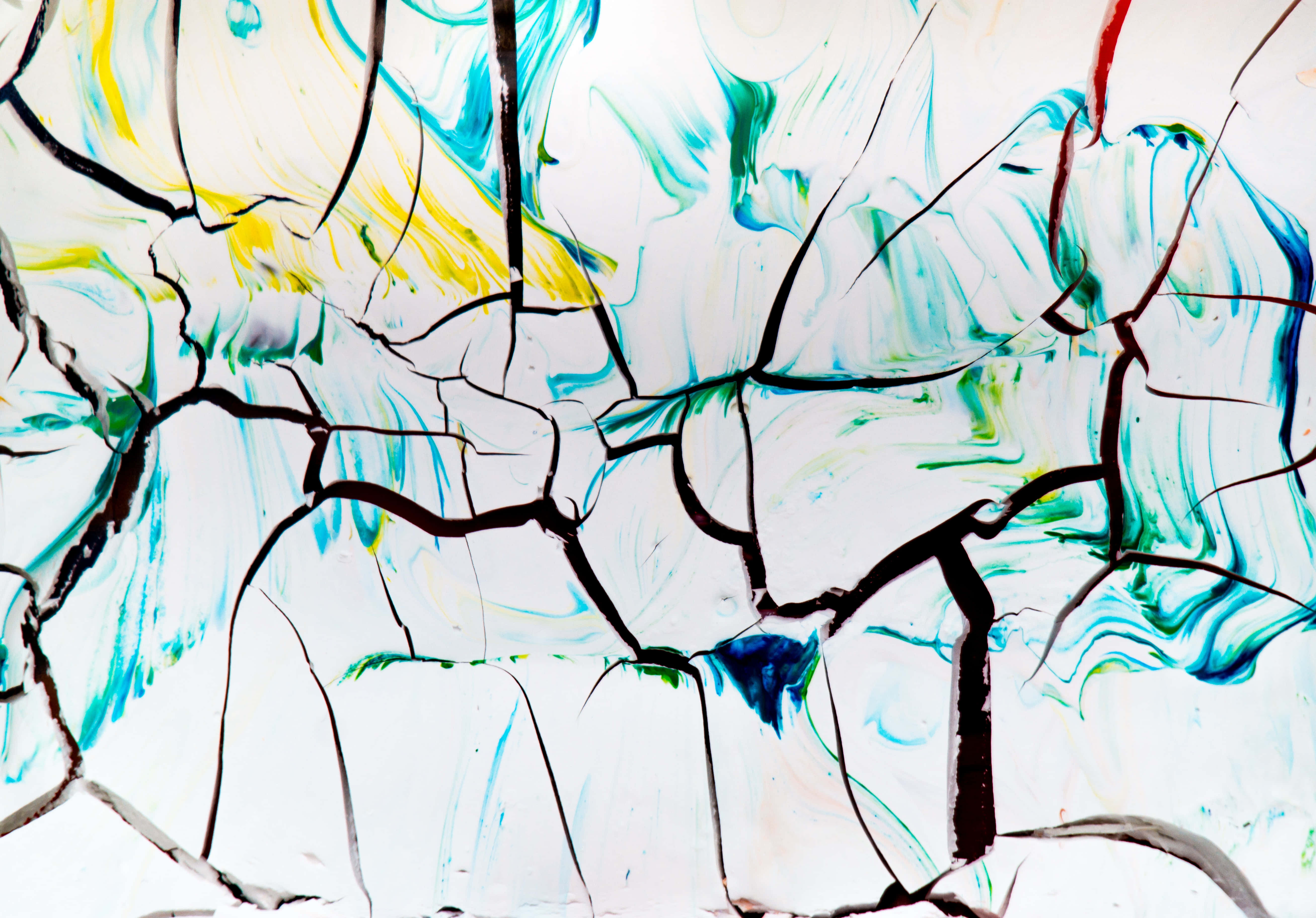 Paint Art 桌布 壁紙 — 藍色、黃色和綠色的鮮豔抽象顏料漩渦，在白色表面上穿過大膽的黑色裂縫迸發而出。