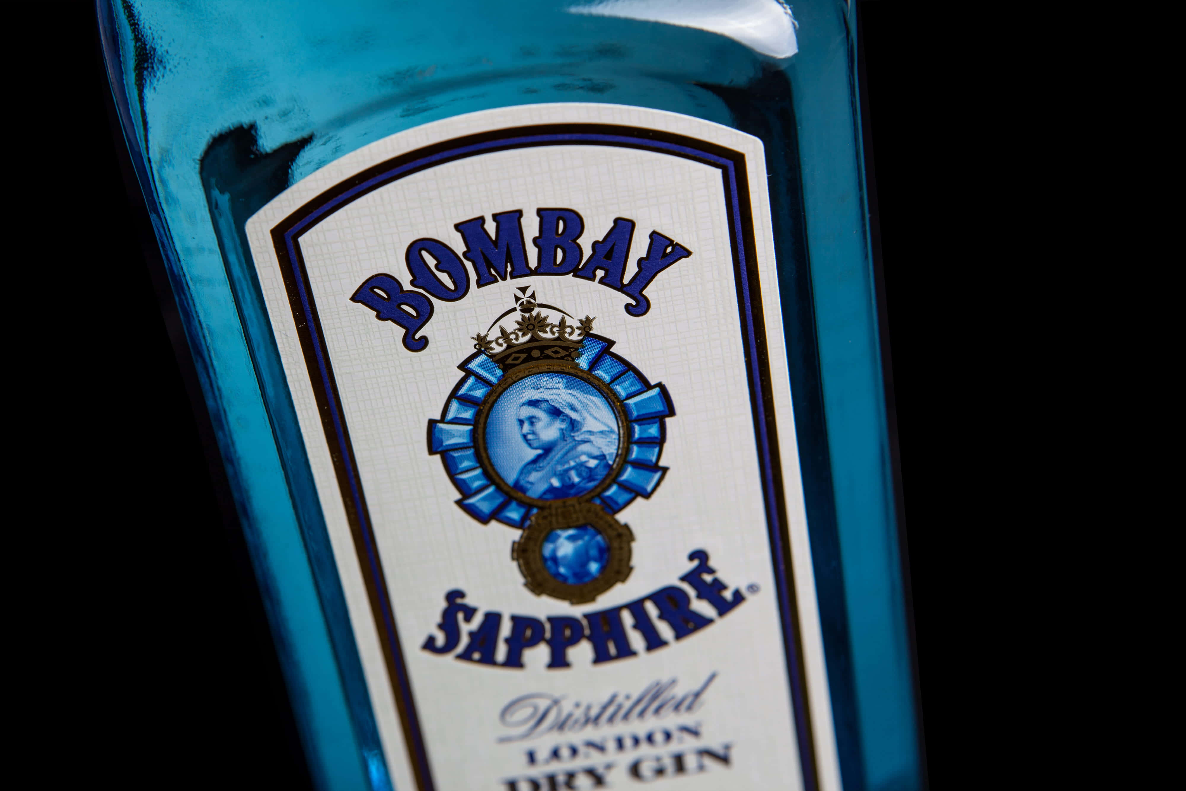 Sapphire Blue 桌布 壁紙 — 藍色Bombay Sapphire琴酒瓶標籤的特寫，背景為黑色。