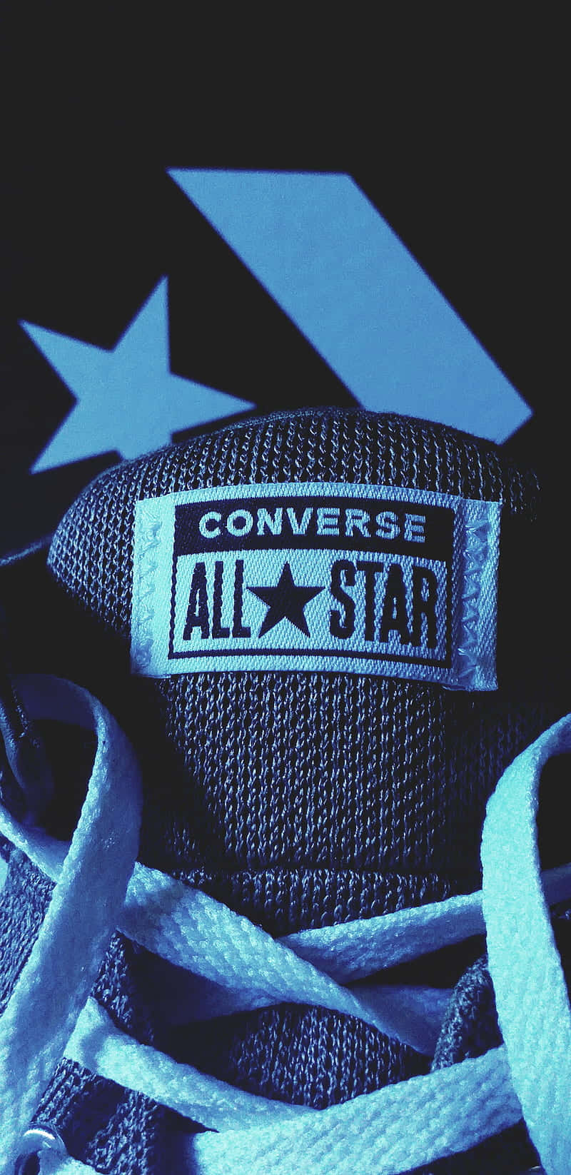 Converse 桌布 壁紙 — 藍色Converse All Star運動鞋特寫，白色鞋帶，深色背景，帶有發光的星星和箭頭標誌。