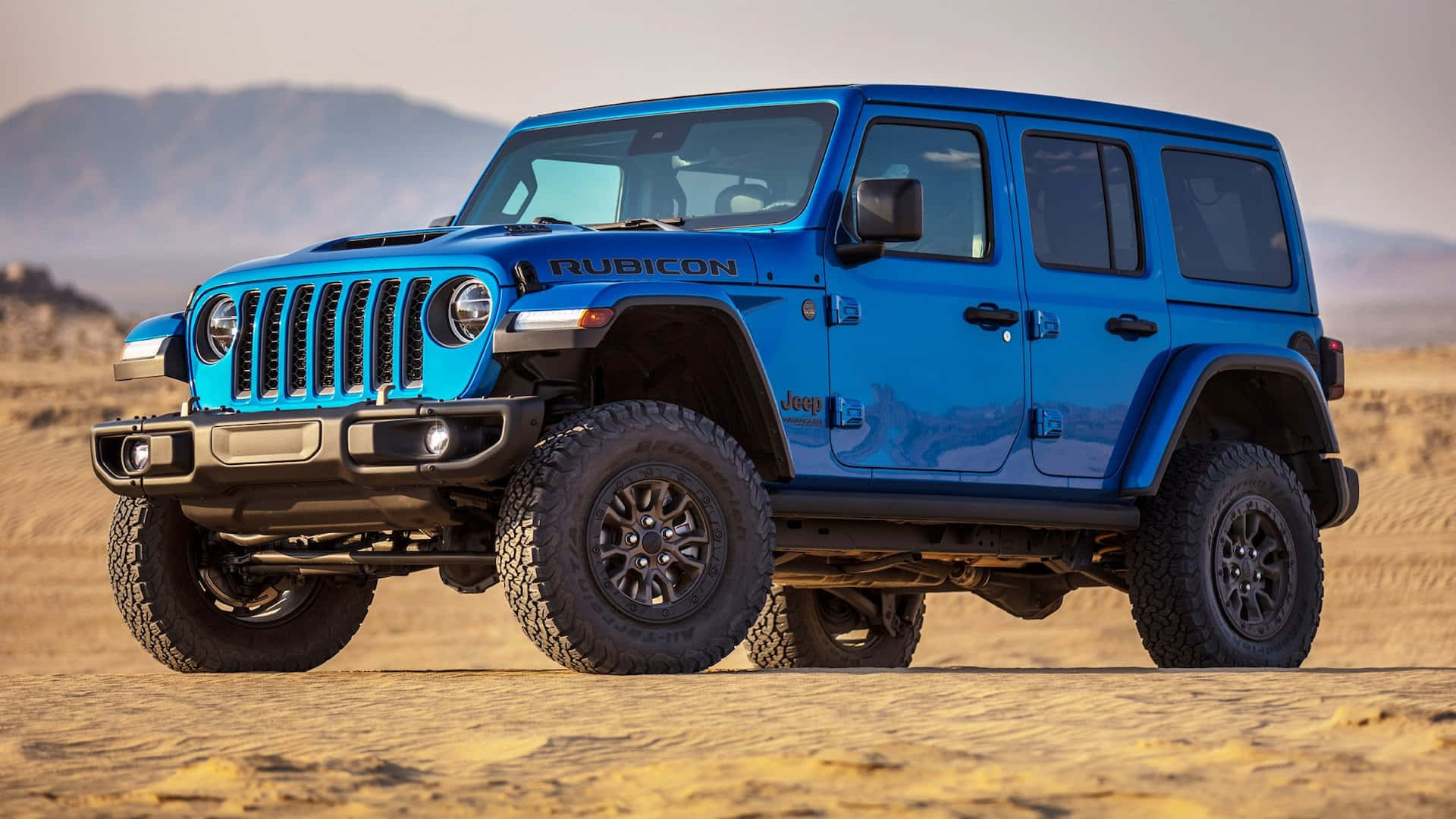藍色Jeep Wrangler在沙漠中行駛 壁紙
