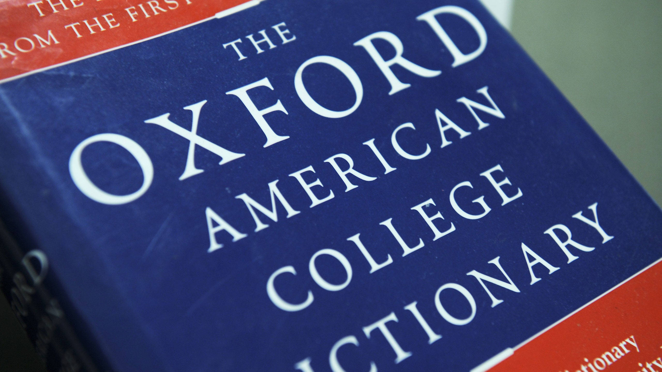 Dictionary 桌布 壁紙 — 藍色Oxford American College Dictionary的特寫，封面有白色襯線文字和紅色點綴。