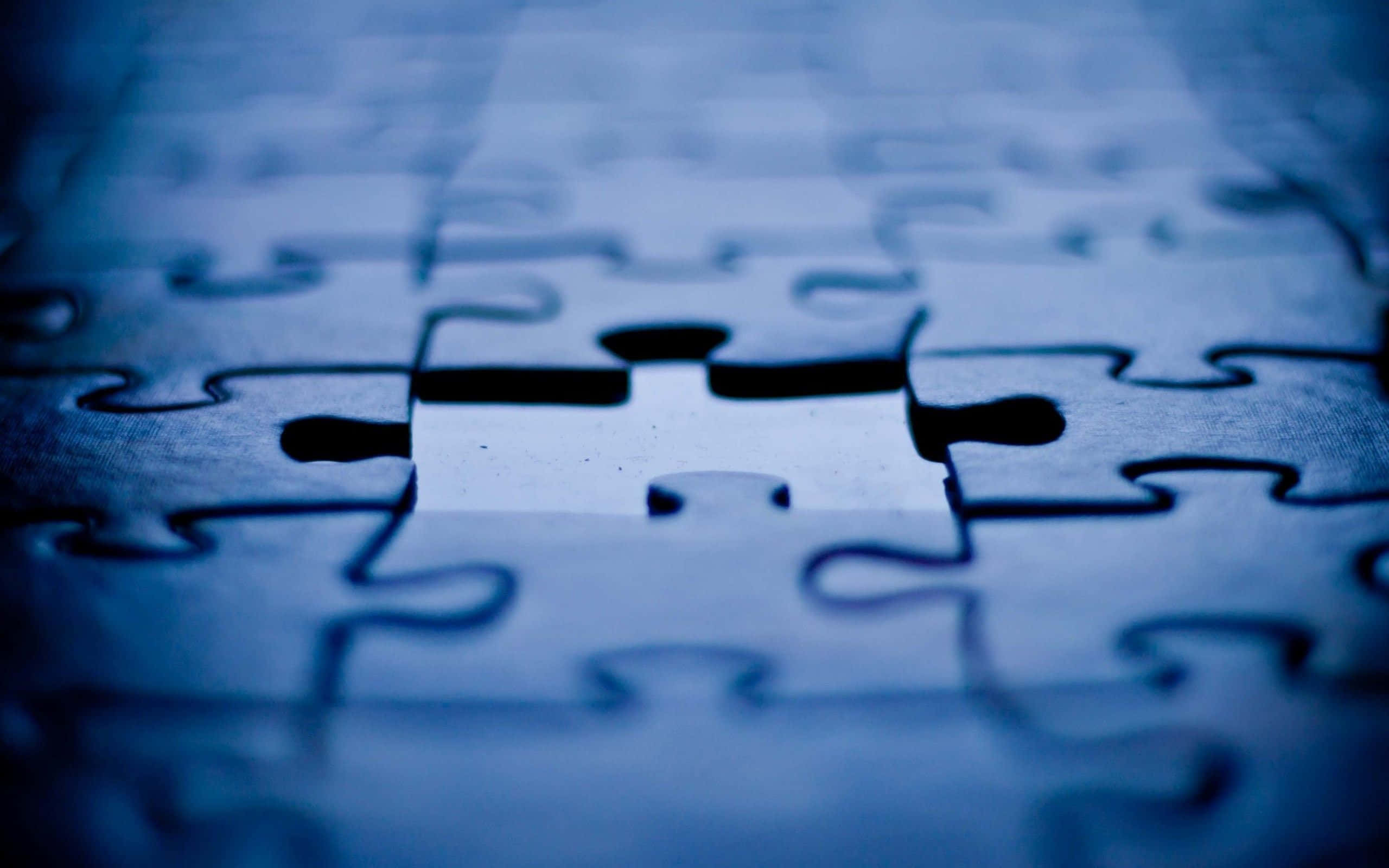 Puzzle 桌布 壁紙 — 藍色拼圖的特寫，中央缺少一塊，在模糊的背景中形成一個鮮明的空洞。