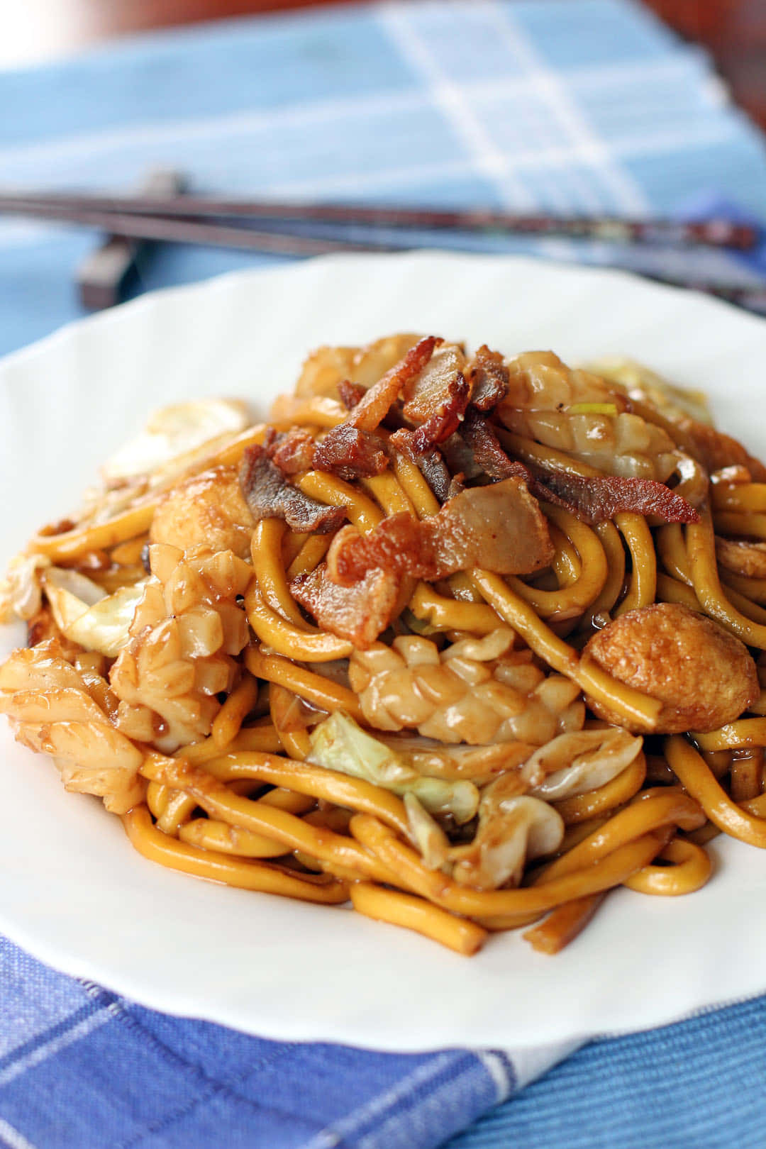 Delicious Food 桌布 壁紙 — 藍色格紋布上白色盤子中雞肉培根蔬菜炒麵的特寫。
