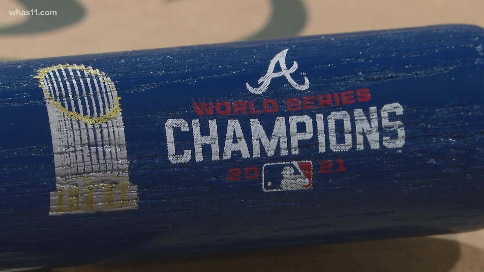 Atlanta Braves Desktop 桌布 壁紙 — 藍色棒球棍的特寫，上面有磨損的油漆寫著「World Series Champions 2021」和亞特蘭大勇士隊標誌。