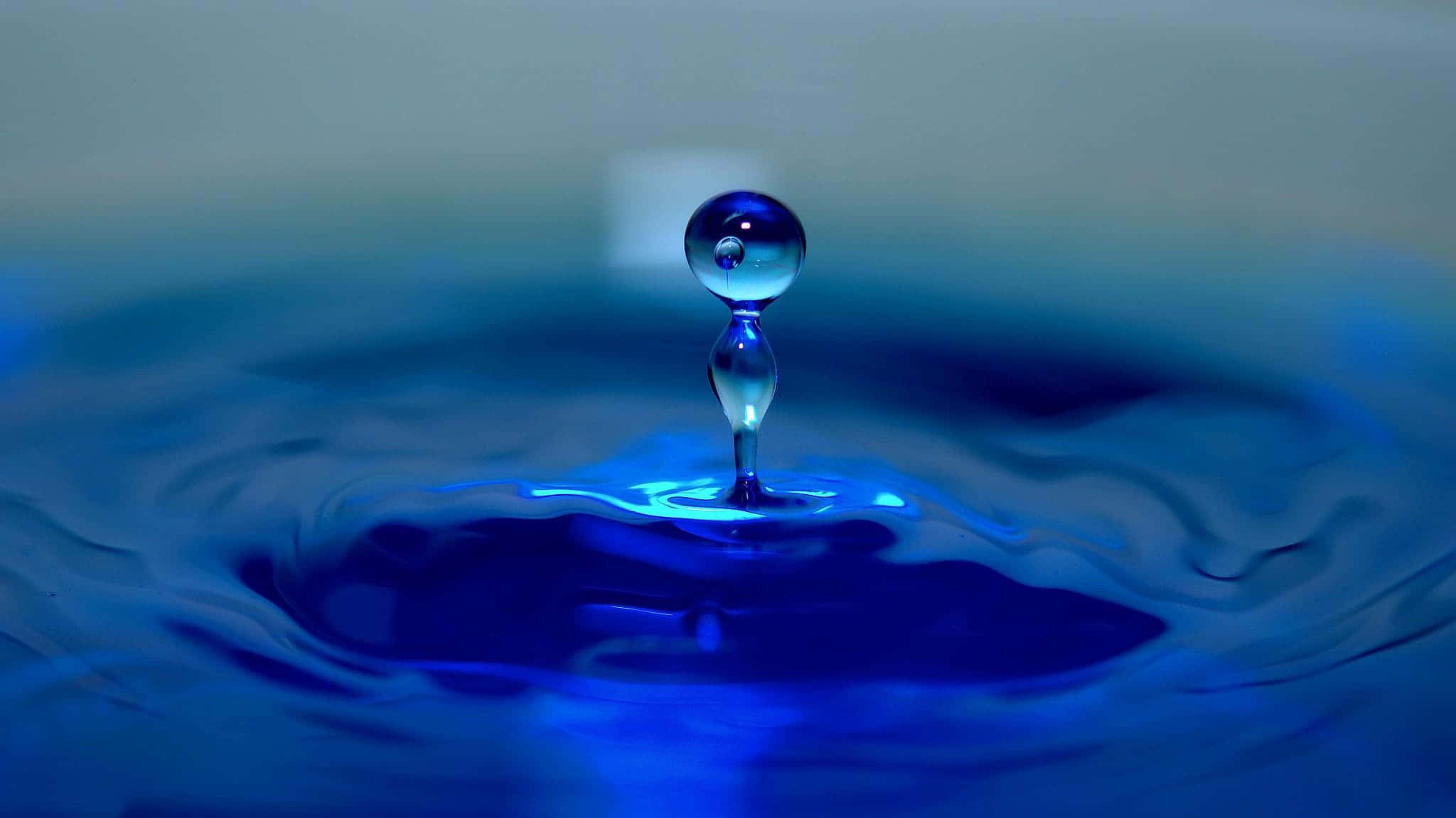 藍色水滴漂浮在一碗水中 壁紙