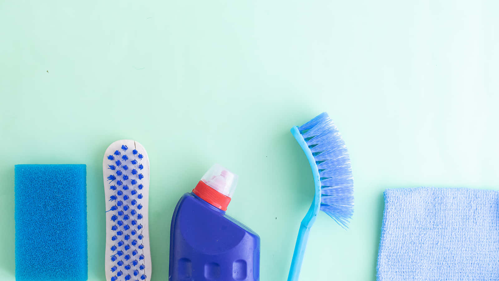 Cleaning 桌布 壁紙 — 藍色清潔工具和海綿整齊地排列在薄荷綠背景上。