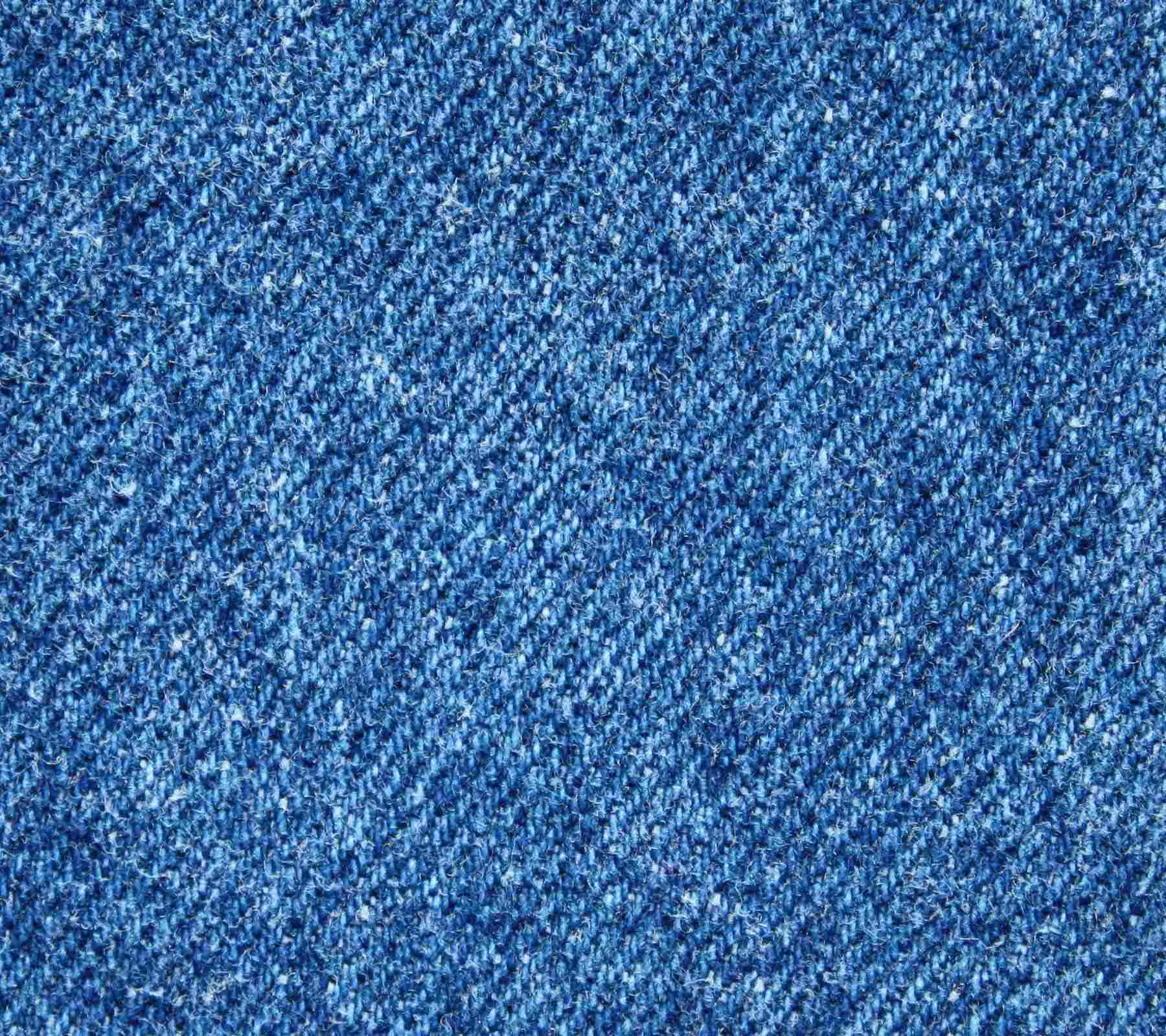 Denim 桌布 壁紙 — 藍色牛仔布料的特寫，具有紋理、多種色調和可見的縫線細節。