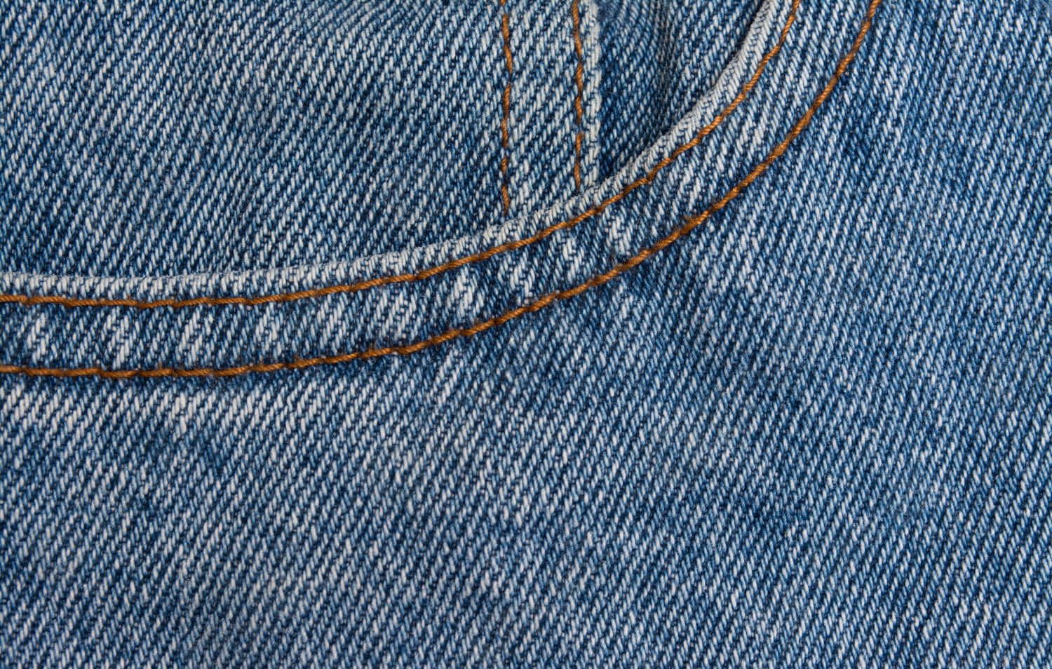 Denim 桌布 壁紙 — 藍色牛仔布料的特寫，橙色縫線勾勒出口袋縫線，顯示出紋理織法。