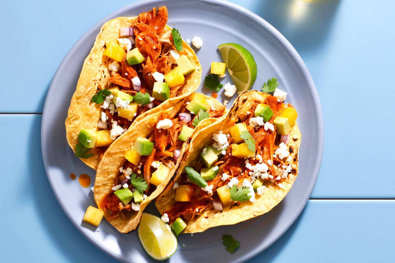Mexican Food 桌布 壁紙 — 藍色盤子上三個色彩繽紛的雞肉絲玉米餅，上面放有芒果、酪梨、香菜和科蒂亞起司。