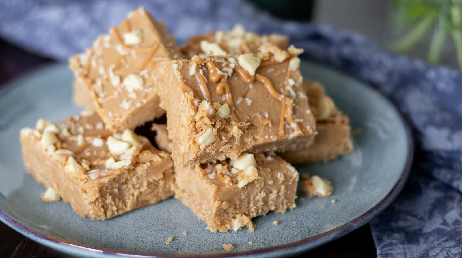 Penuche Fudge 桌布 壁紙 — 藍色盤子上放著淋上焦糖醬並撒上碎堅果的奶油花生醬軟糖方塊。