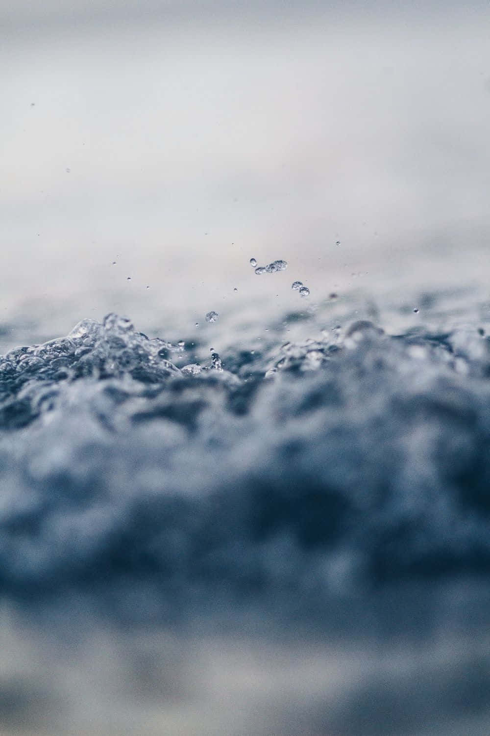 Edgy 桌布 壁紙 — 藍色紋理水的特寫，水滴在運動中懸浮，背景柔和模糊。