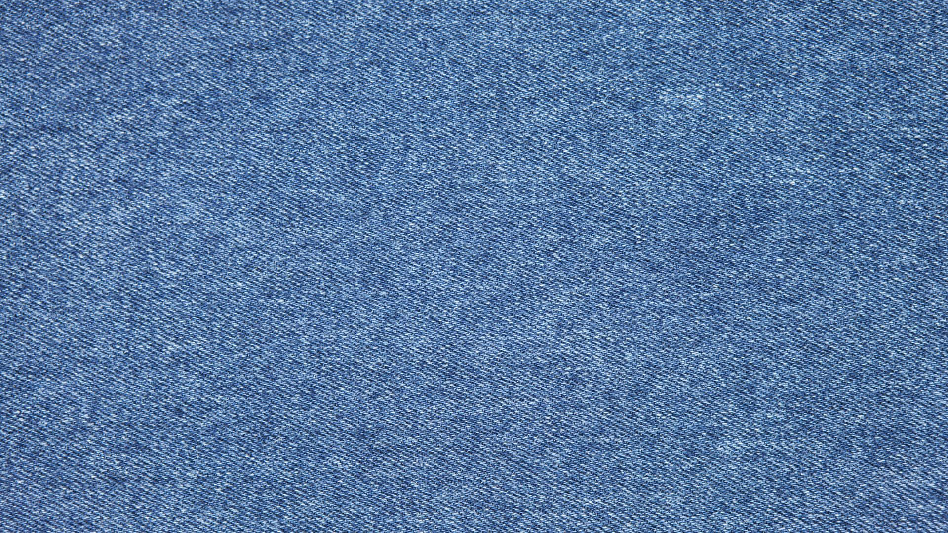 Textured 桌布 壁紙 — 藍色紋理牛仔布料的特寫，顯示詳細編織和細微褪色。