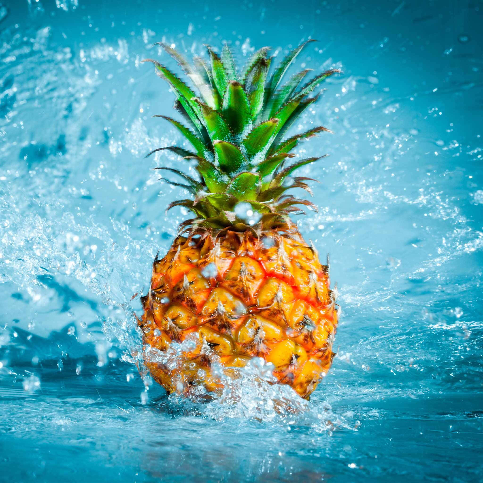 藍色背景上在水中濺起的鳳梨 壁紙
