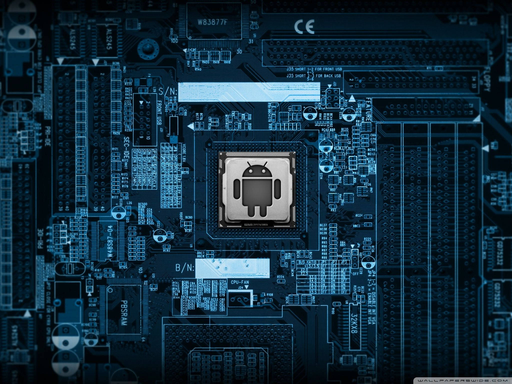安卓 桌布 壁紙 — 藍色調電腦主機板的特寫，中央有Android標誌晶片。