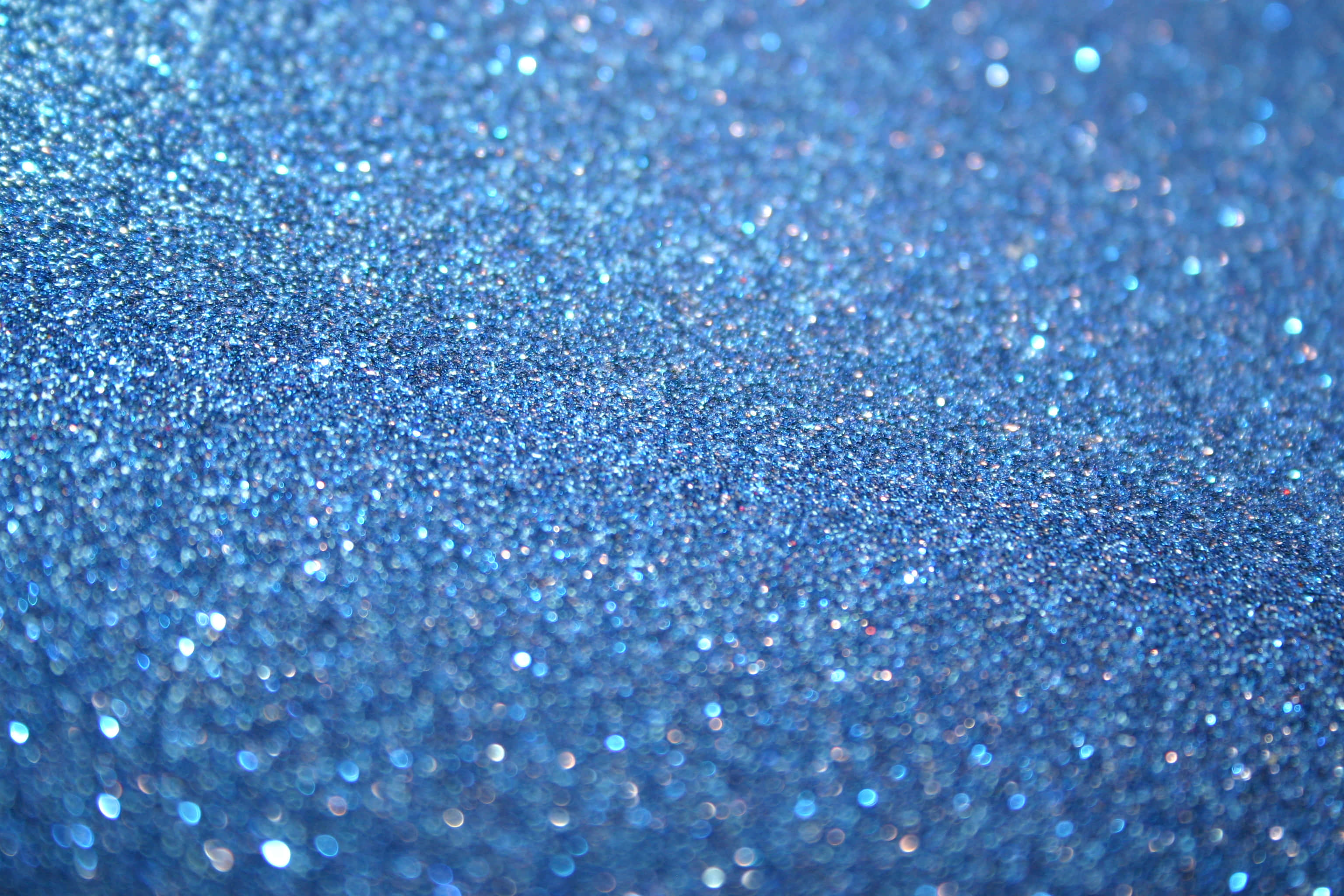 Blue Sparkle 桌布 壁紙 — 藍色閃粉的特寫，帶有閃爍高光和柔和散景效果。