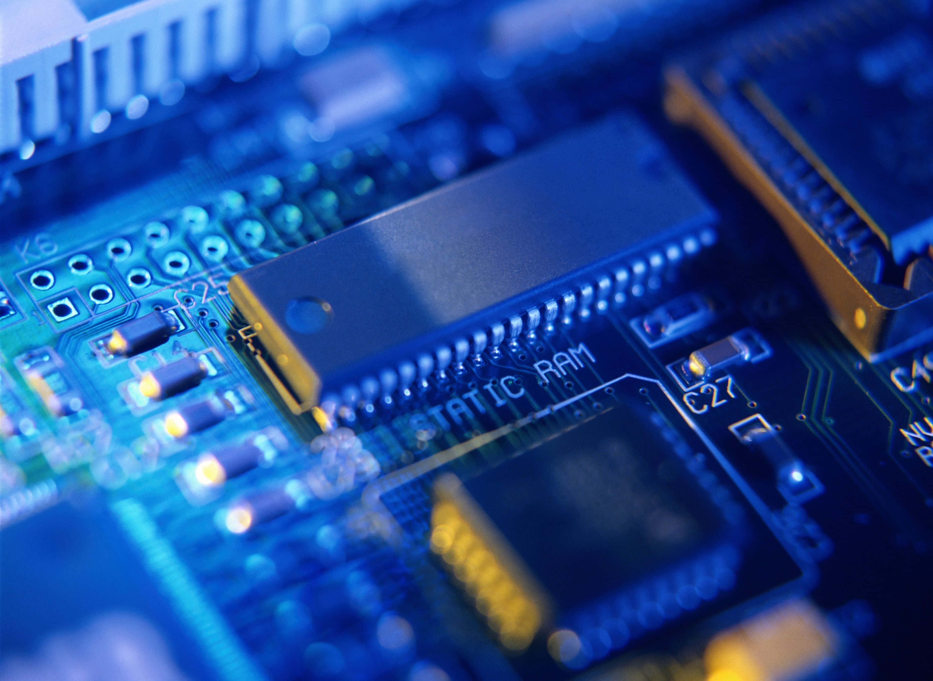 Electronic Components 桌布 壁紙 — 藍色電路板特寫，帶有靜態RAM晶片在冷光下發光。